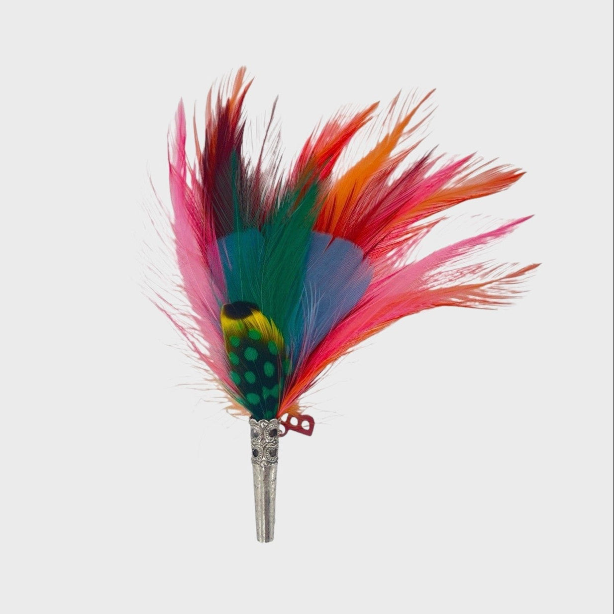 Pink, red, orange, blue and green feathered brooch on a light gray background