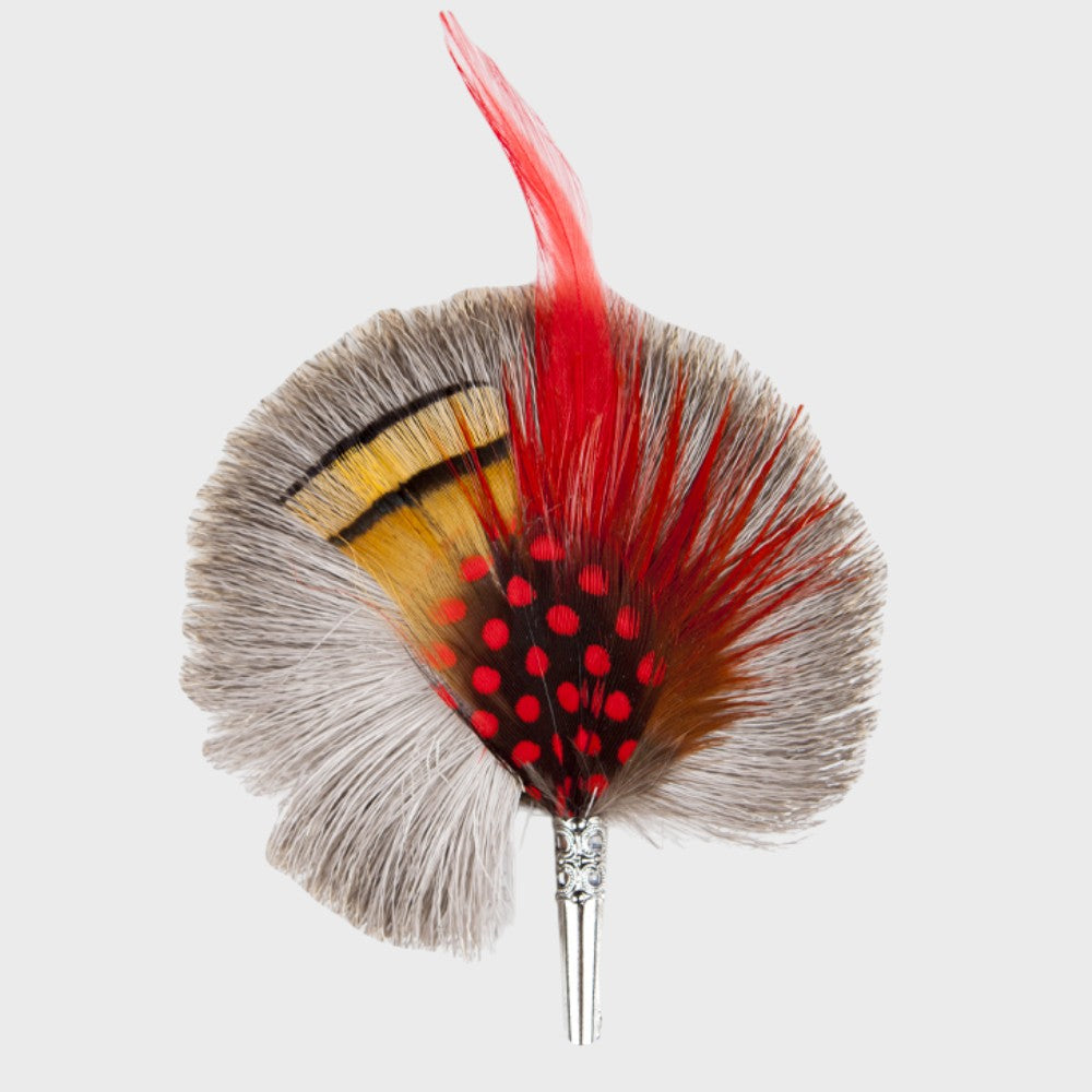 Red, grey and yellow feathered brooch on a light gray background