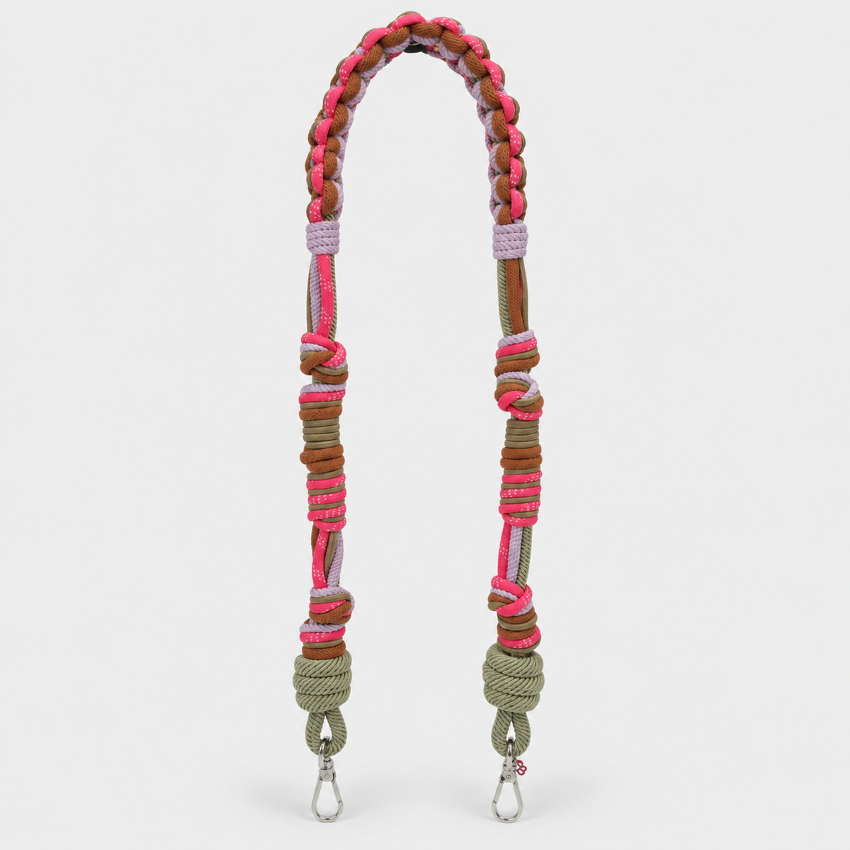 A multi-coloured braided macrame shoulder strap with pink, brown, and purple accents, featuring silver metal snap hooks at the bottom, shown against a light gray background.