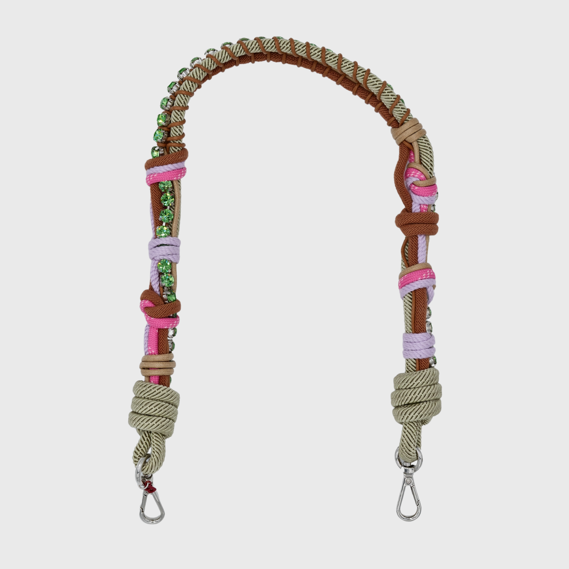 Multicolored braided macramé bag strap in pink and green, featuring some green colored beads and shown on a light grey background.