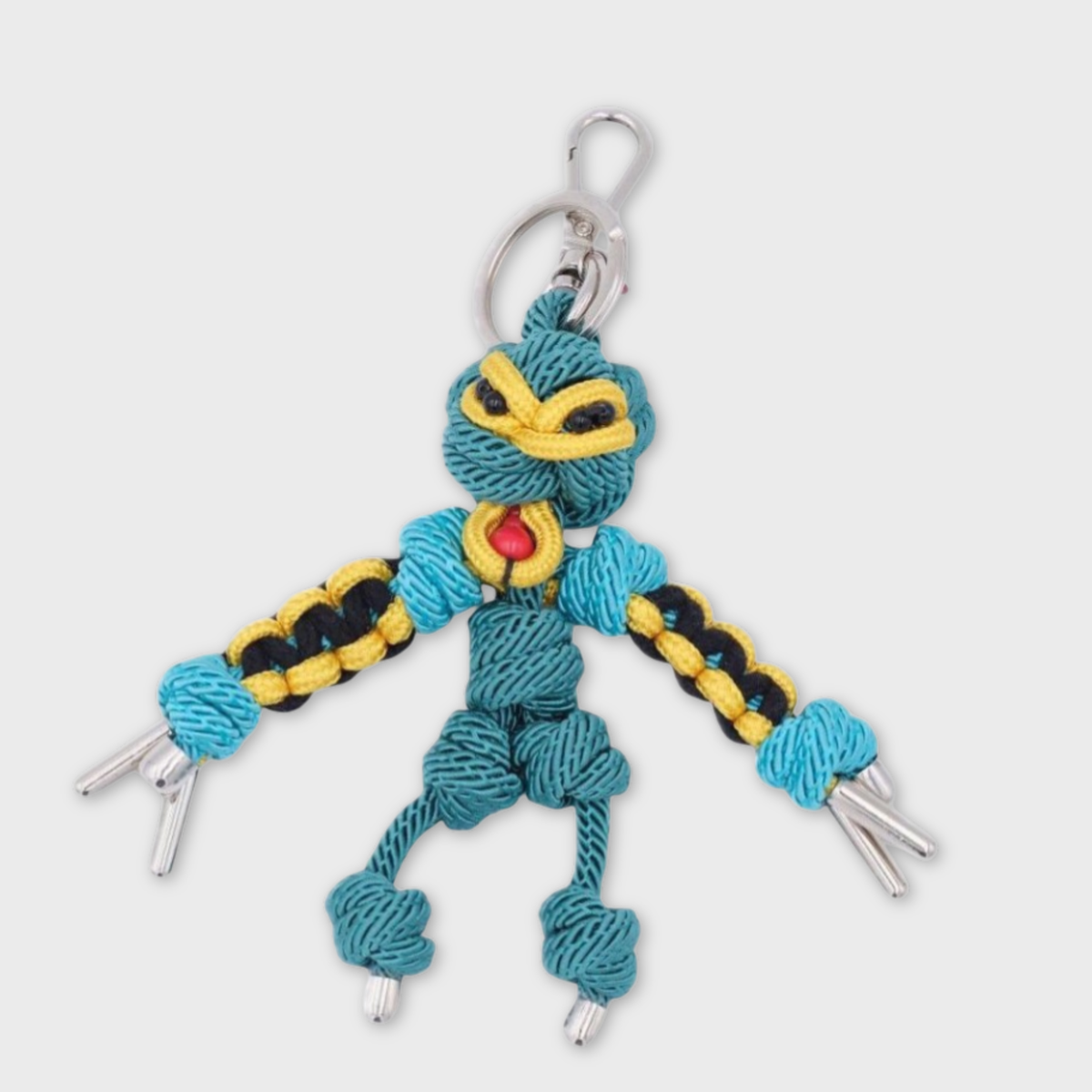 Handmade blue and yellow macramé bag charm featuring a character, meant to represent a Polynesian divinity. They are attached to a silver clasp.