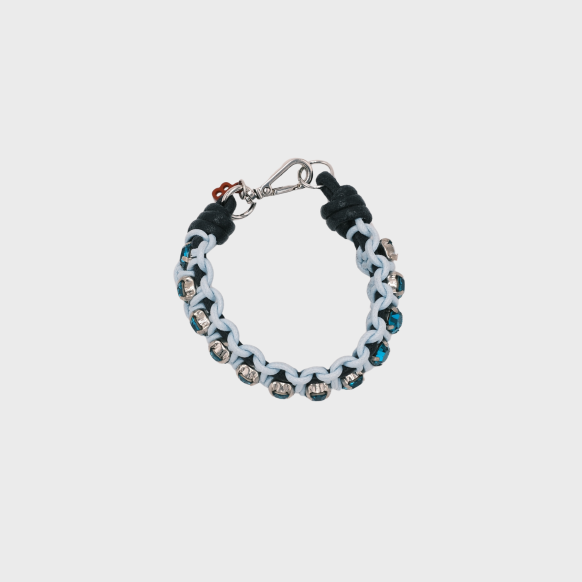 A handmade macramé woven bracelet featuring a mix of blue threads, accented with small blue beads and a silver clasp.