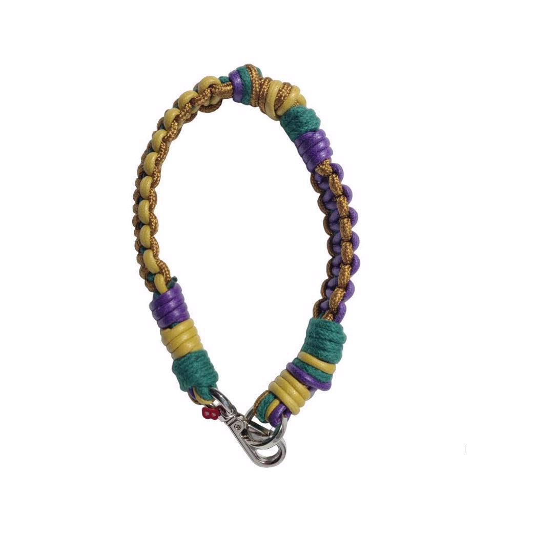 A photo taken from above of a braided macramé cord collar in shades of brown, purple and green with a silver clasp.