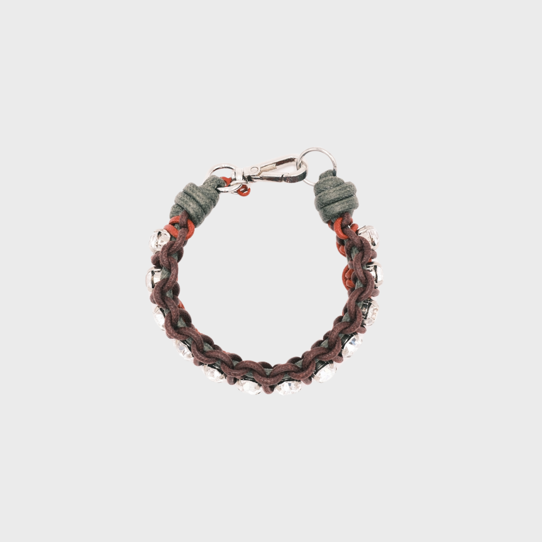 A handmade macramé woven bracelet featuring a mix of brugundy, green and red threads, accented with small white beads and a silver clasp.