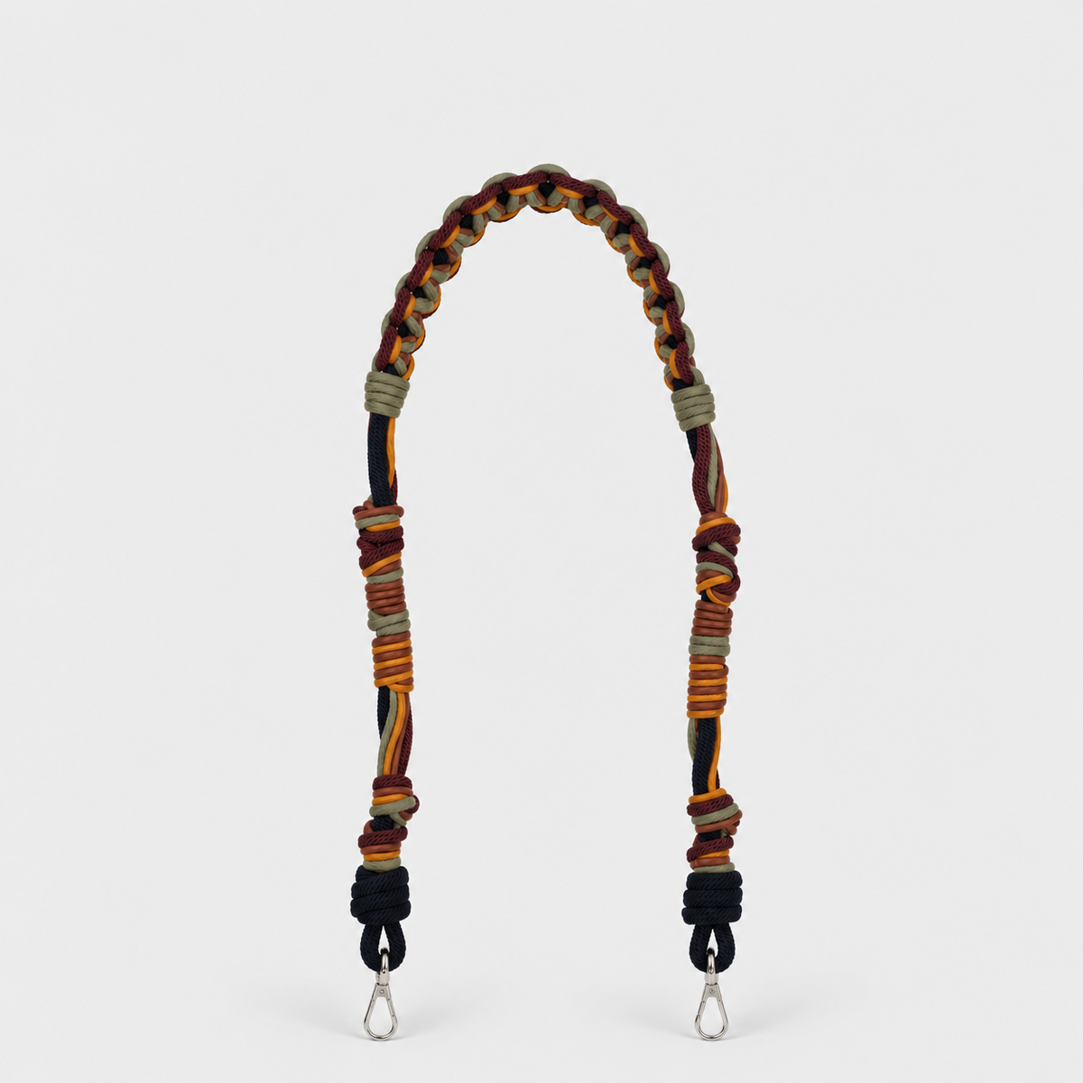 A multi-colored macramé bag strap with silver metal clips at the bottom, photographed against a light gray background.