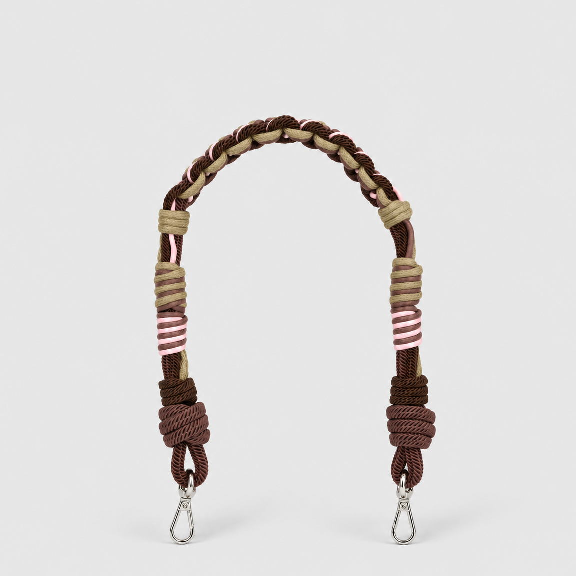 A braided and knotted macrame shoulder strap in brown, beige, and pink, with silver metal snap hooks at the ends, shown on a light gray background.