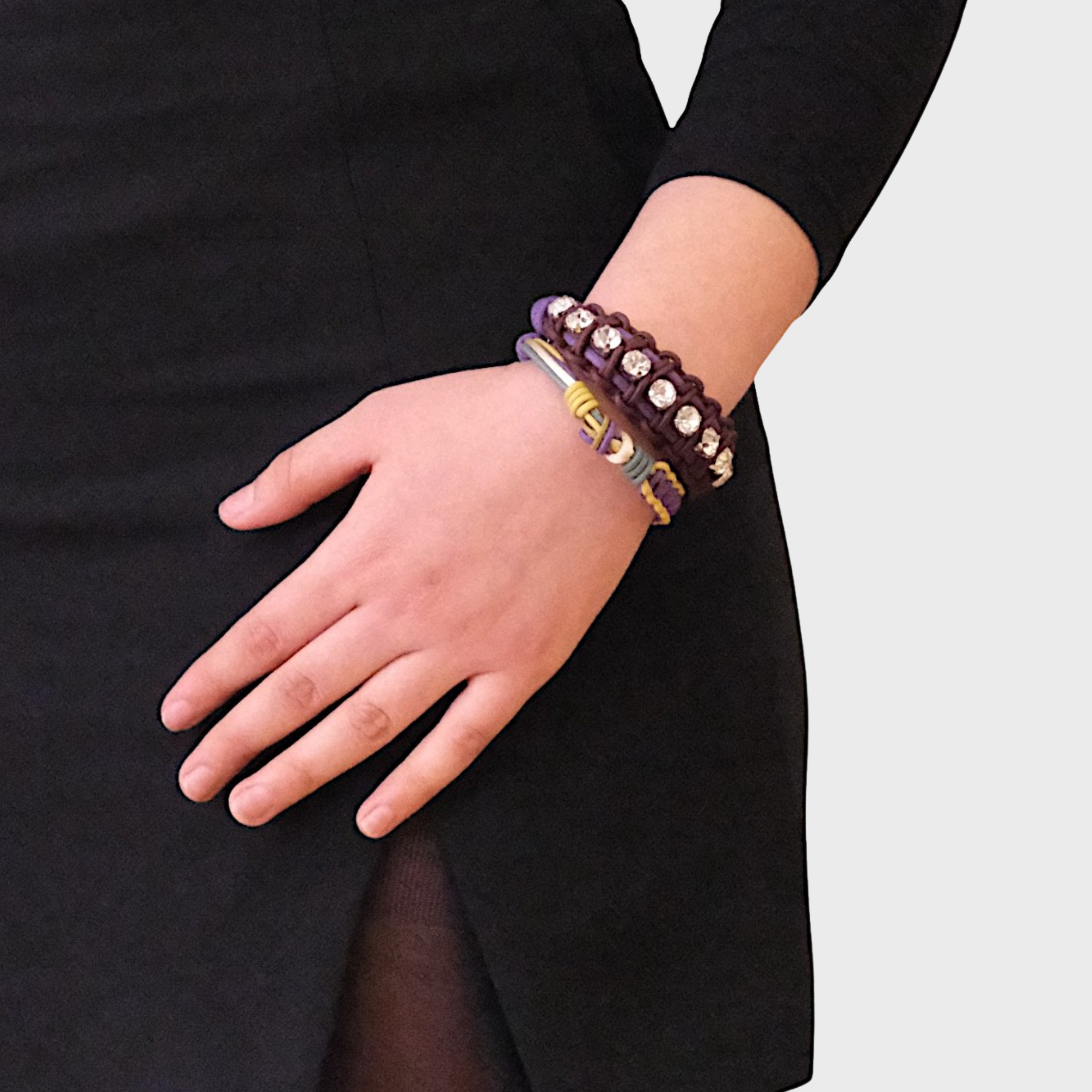 A model wearing two bracelets including the yellow, purple and green Nino bracelet
