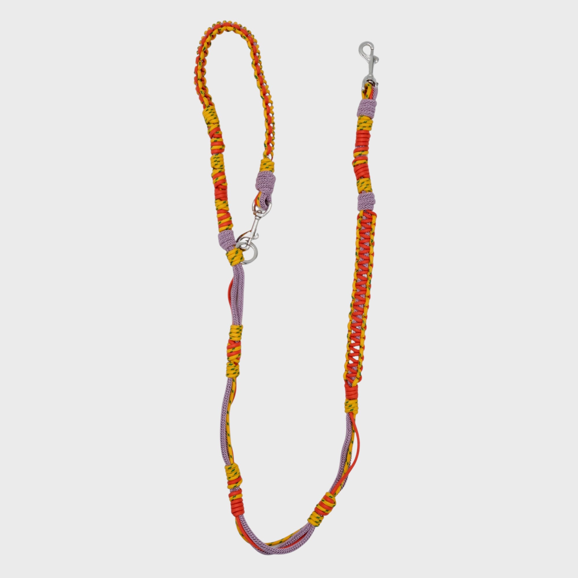 A braided macramé dog leash with yellow, orange and purple woven sections, and a silver metal hardware