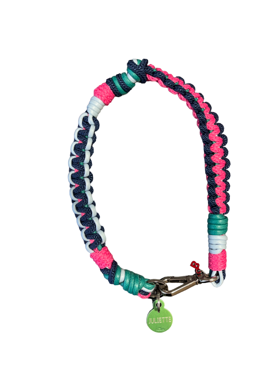 A photo taken from above of a braided macramé cord collar in shades of bright pink, light blue and dark blue with a silver clasp.