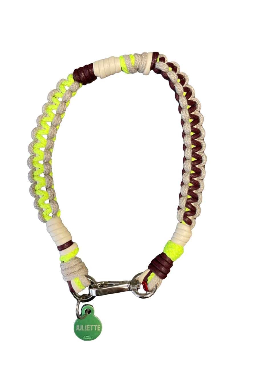A photo taken from above of a braided macramé cord collar in shades of neon yellow, beige and brown with a silver clasp.
