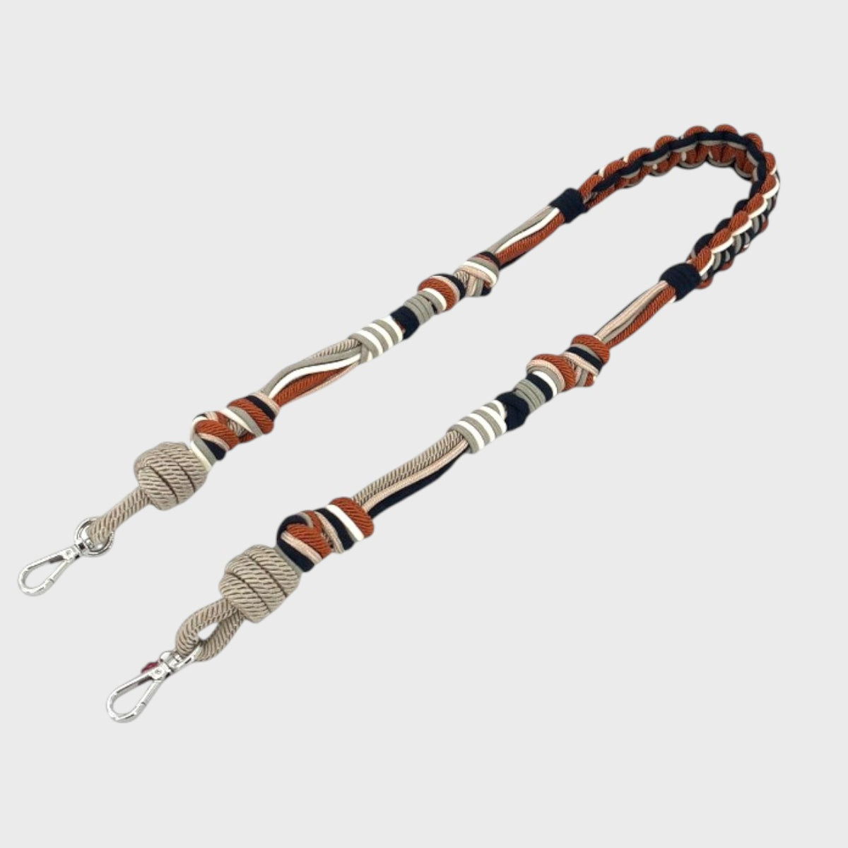 Awhite, grey, black and red macramé bag strap. 