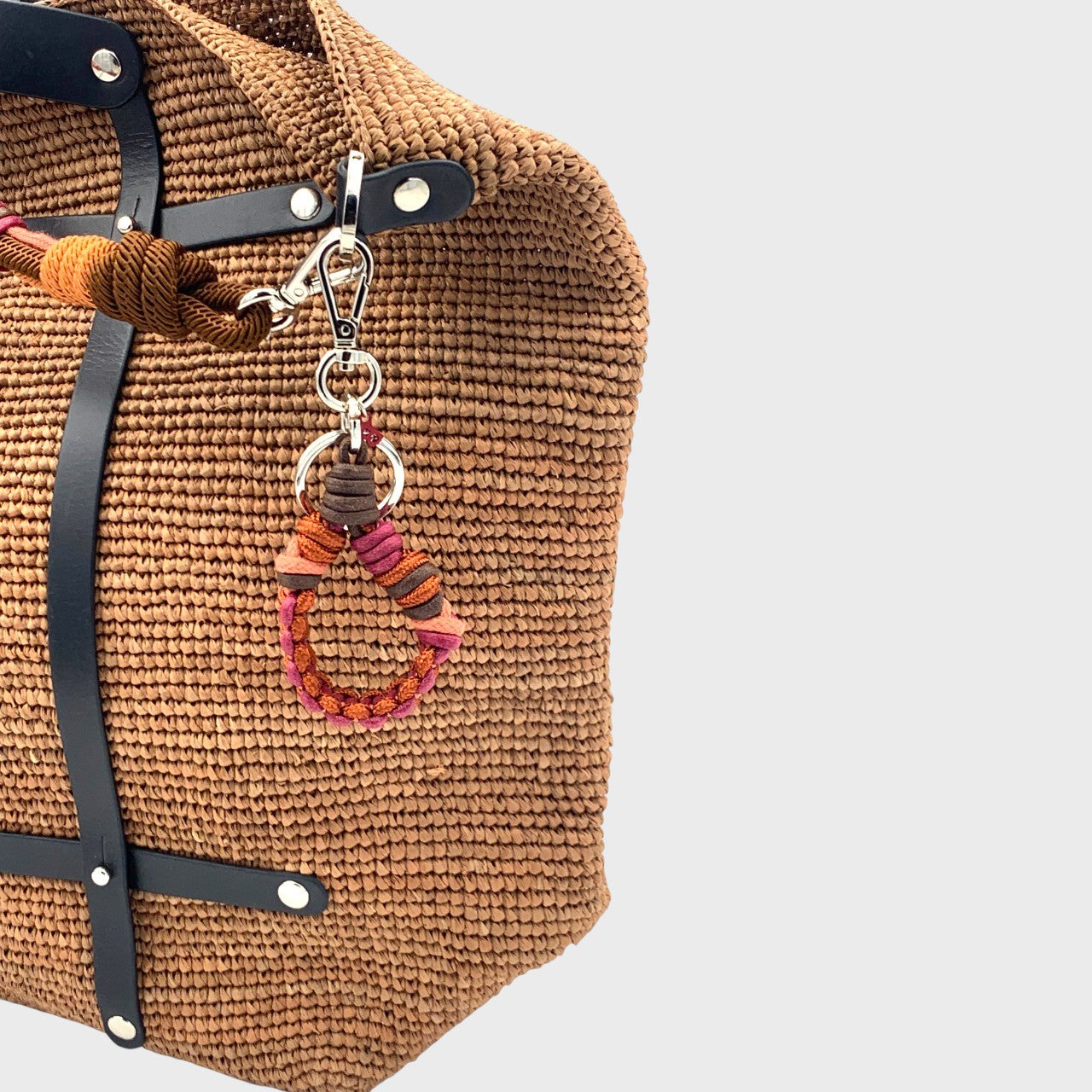 The burgundy Harold key ring clasp to a bag. 