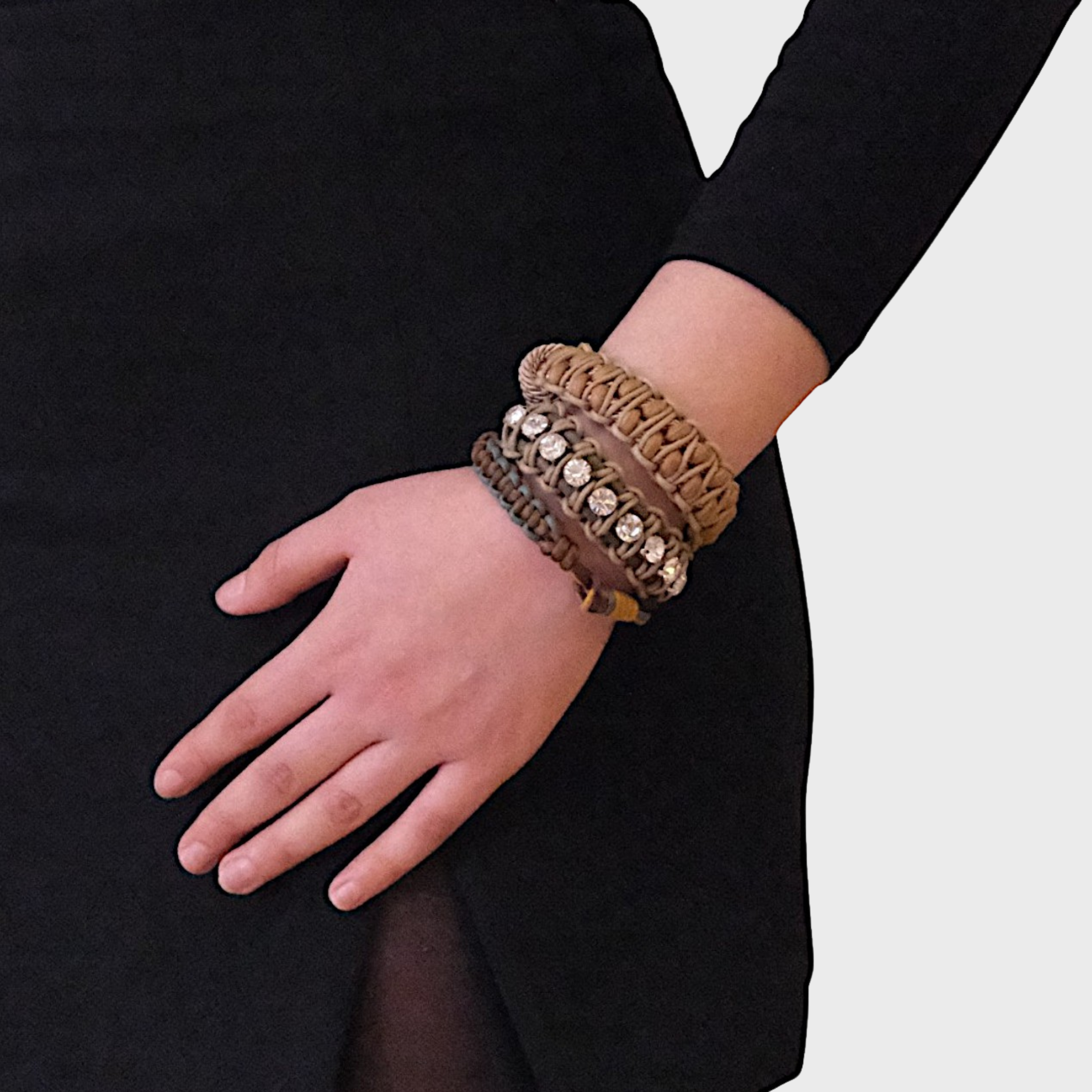 A model wearing several bracelets including the green and beige Juliette bracelet with small white beads