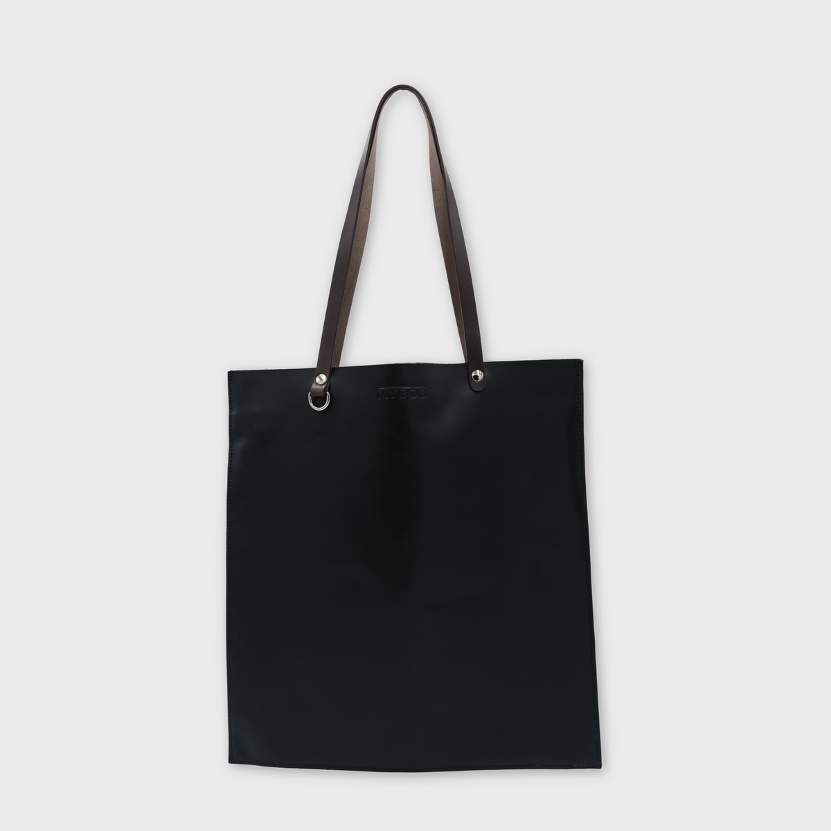 A black canvas tote bag with dark brown shoulder straps and silver-tone metal grommets, shown against a light gray background.