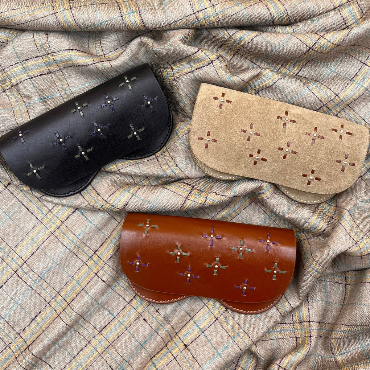 Three embroidered glasses cases. 