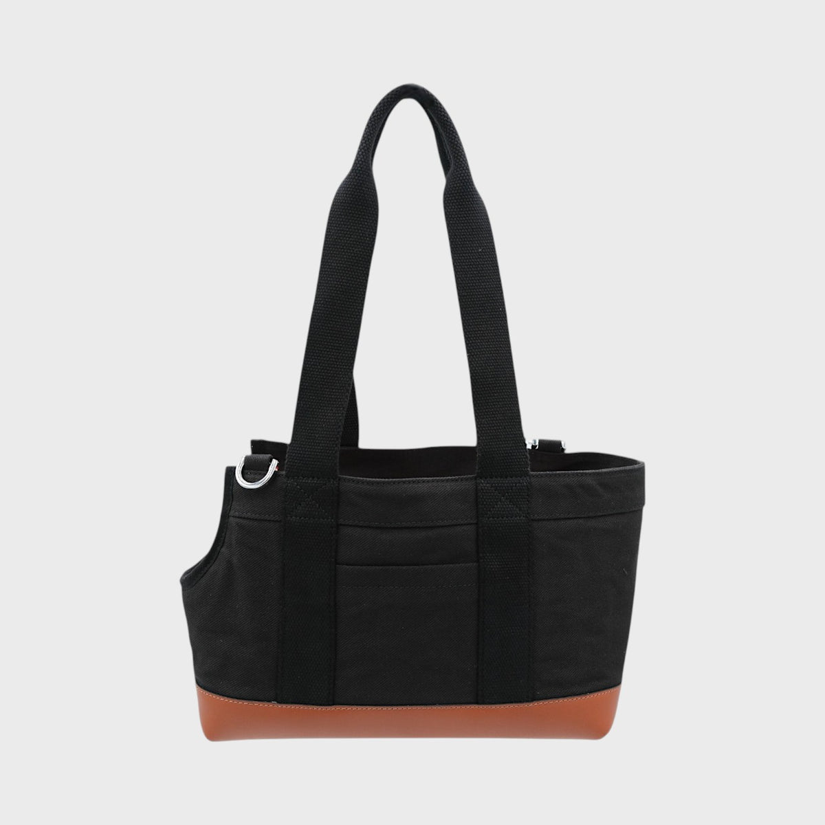 Black dog bag with brown bottom section on a light gray background
