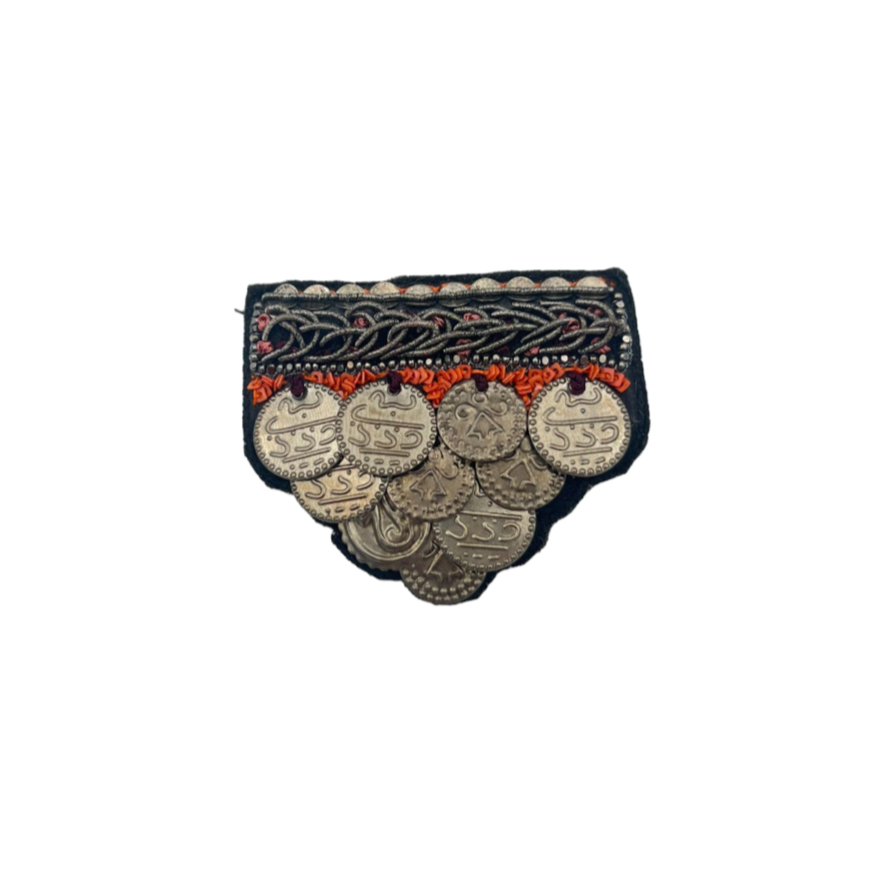 A medal-like brooch with red and grey. 