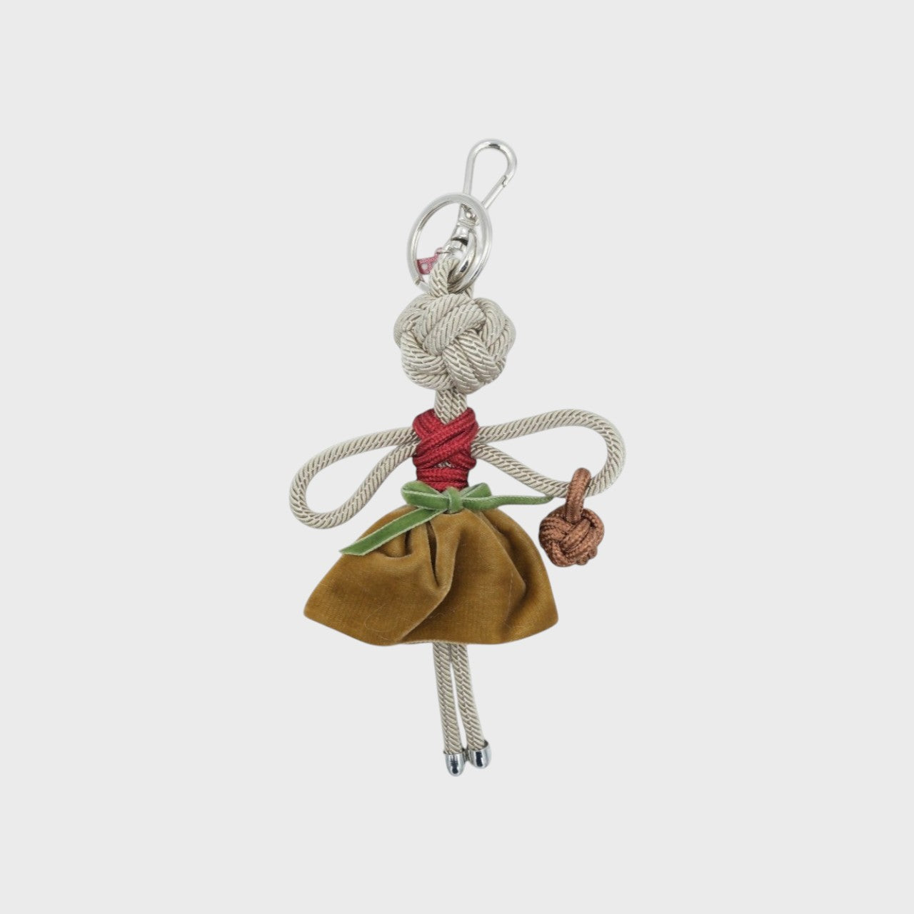BLANCHE character key charm stands out in a mustard yellow velvet skirt and red macramé top, finished with a green ribbon for a bold, handcrafted look.