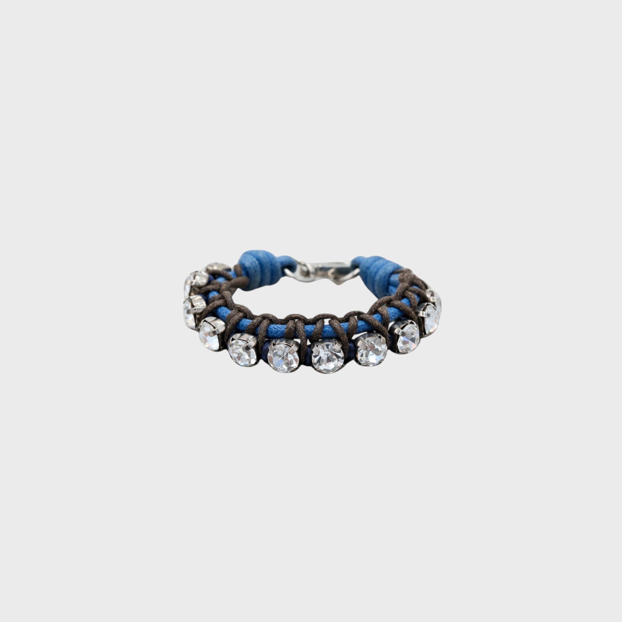 A braided macramé bracelet featuring brown and blue cords with small white beads.