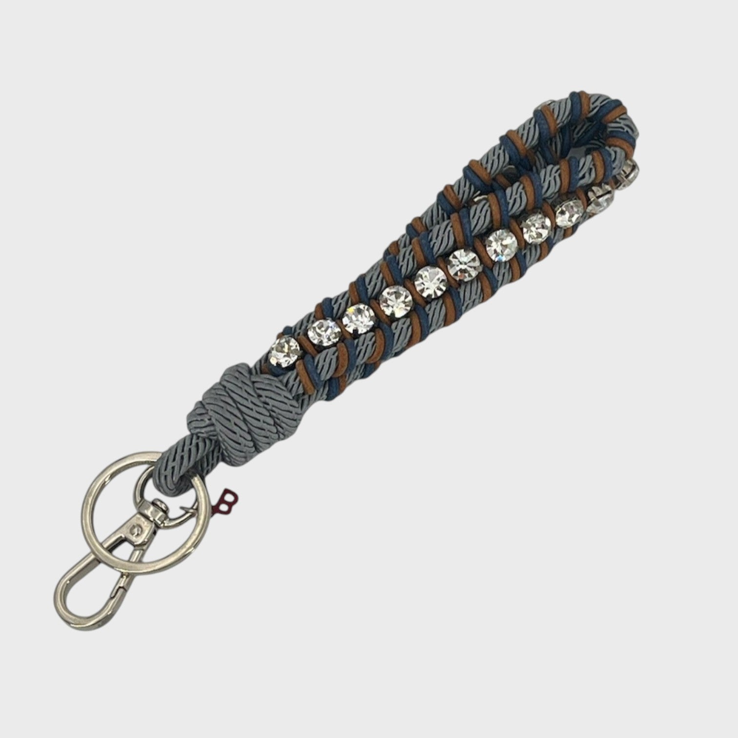 Keychain with blue and brown patterned band and rhinestones on a white background