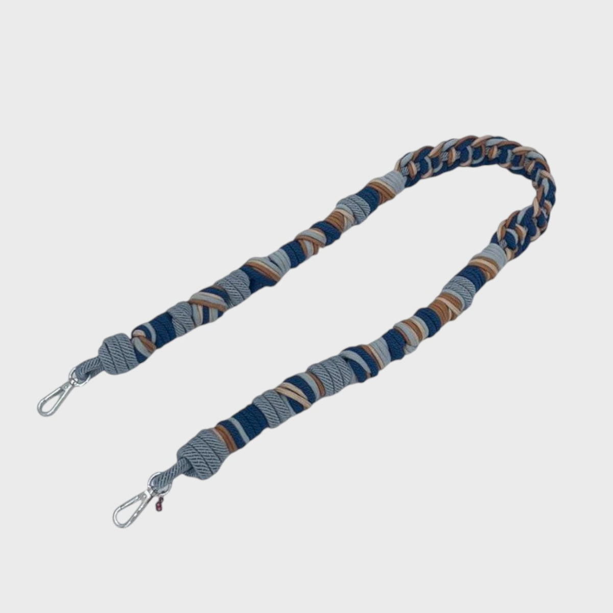Breaded macramé bag strap on a light gray background