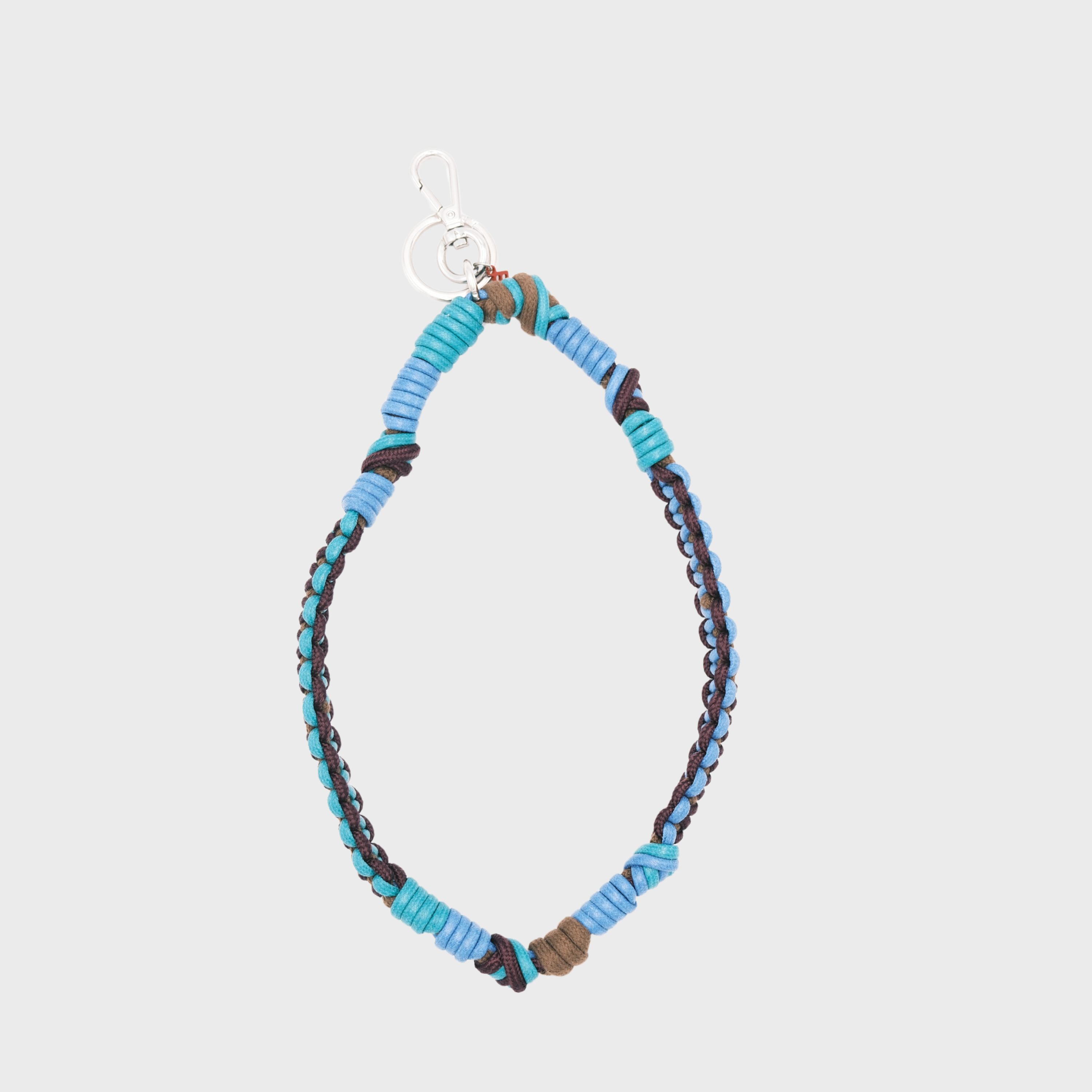 A bohemian-style woven macramé key chain with a silver-tone lobster clasp, featuring bright blue and green, and brown woven segments on a light gray background.