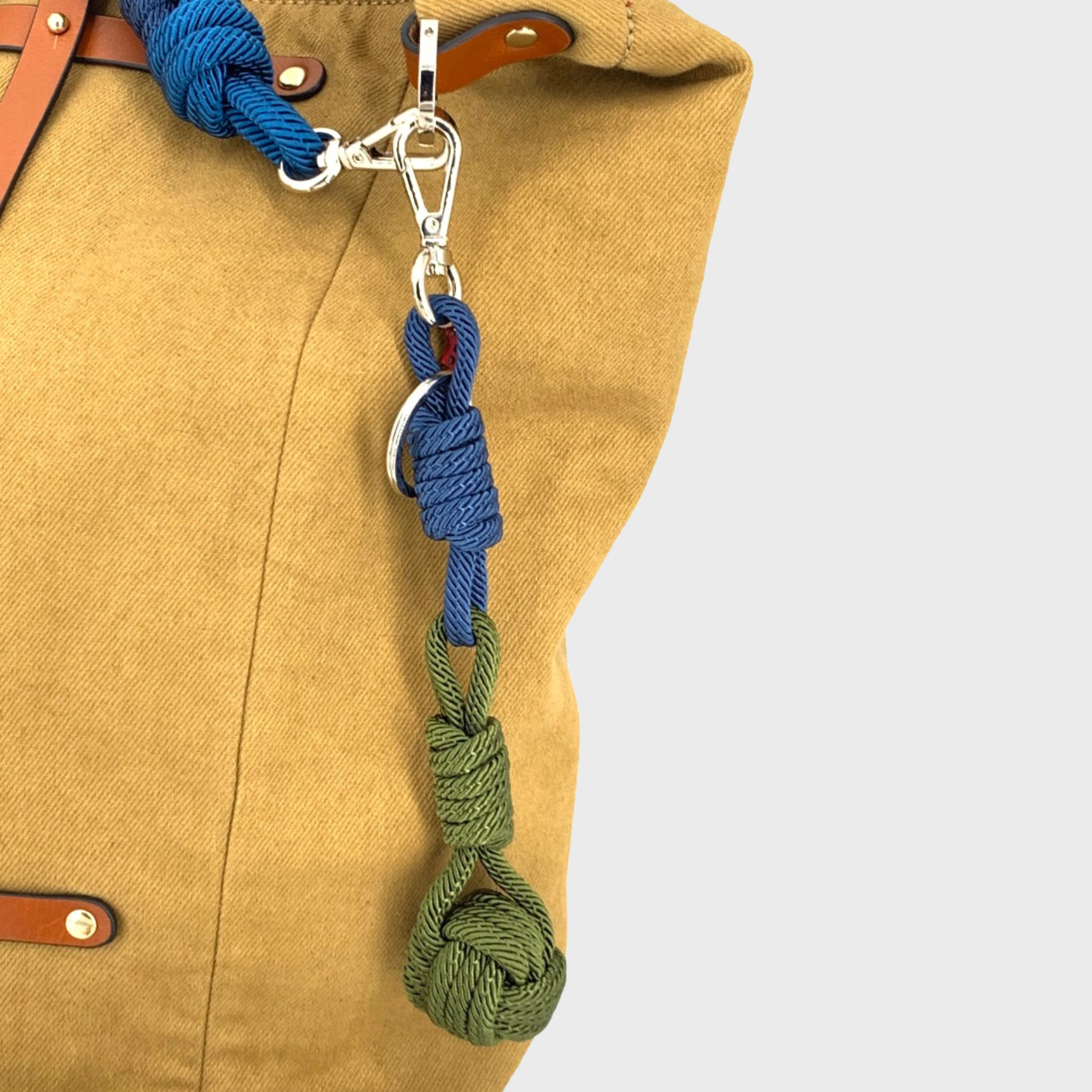 A blue and green sailor ball keychain on a yellow bag. 