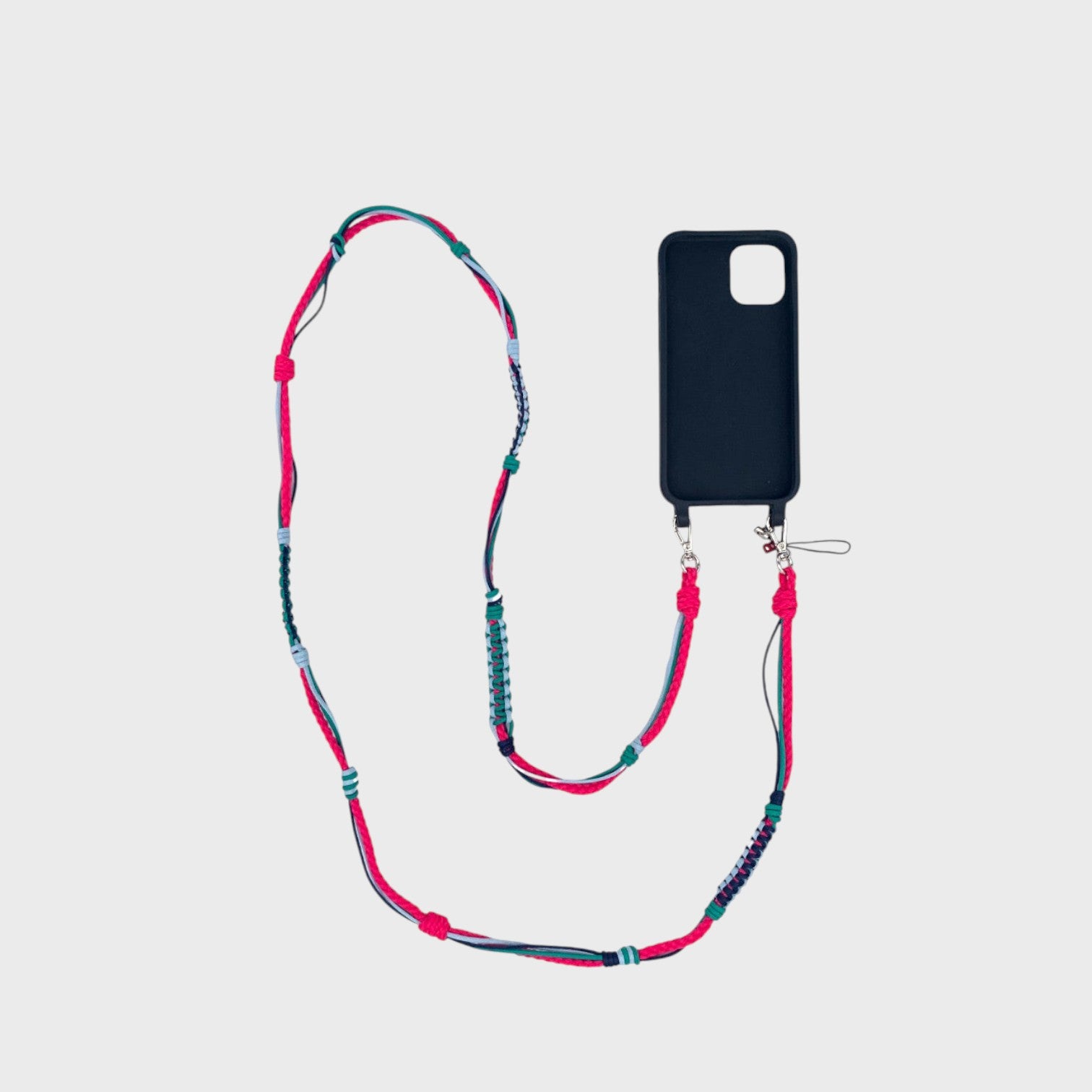 Bright pink, blue and green macramé woven phone lanyard with a black phone case on a white background. 