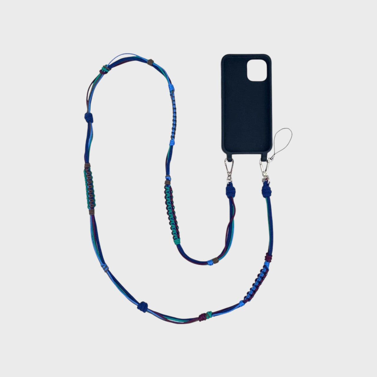Blue, green and purple macramé woven phone lanyard with a black phone case on a white background. 