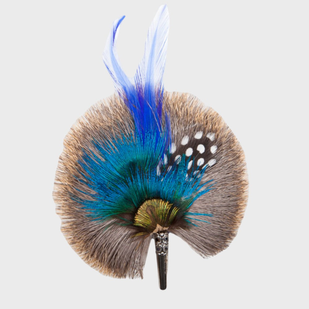 Grey and blue feathered brooch on a light gray background