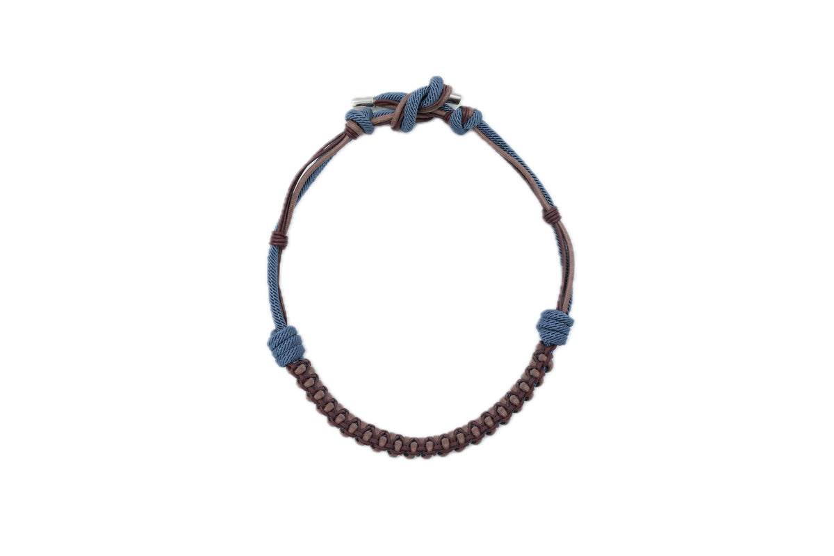A macrame hat band with blue and brown patterns. 