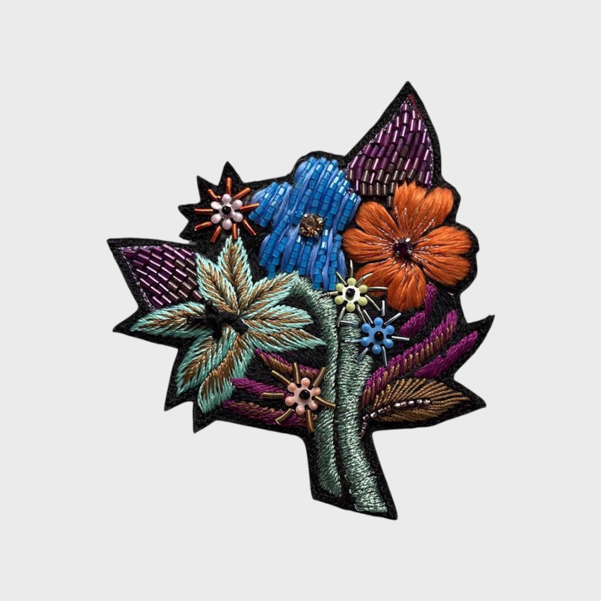 Colorful embroidered floral design brooch on a white background