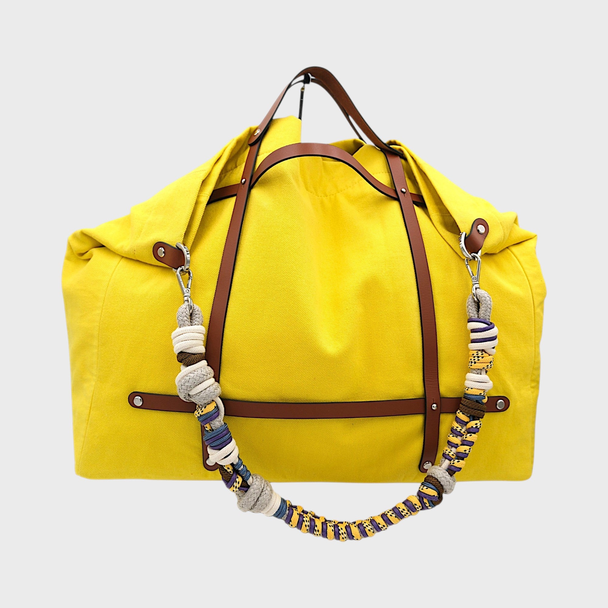 Yellow canvas weekend or duffle bag with a tan leather harness, paired with a colourful shoulder strap in purple, yellow, white and blue.