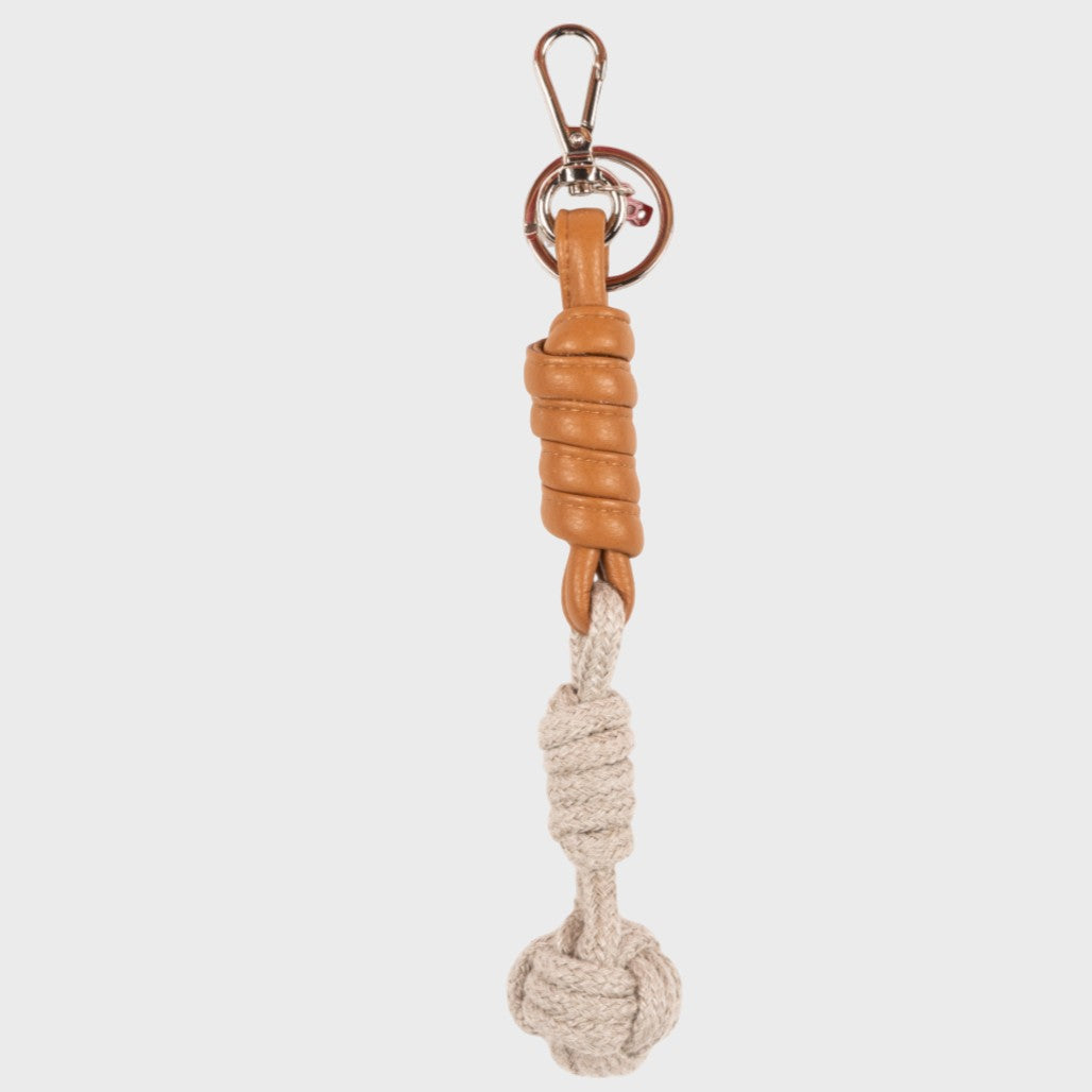 A macramé keychain representing a ball inspired by sailors knots. The straight upper part is leather brown and the ball part is beige. 