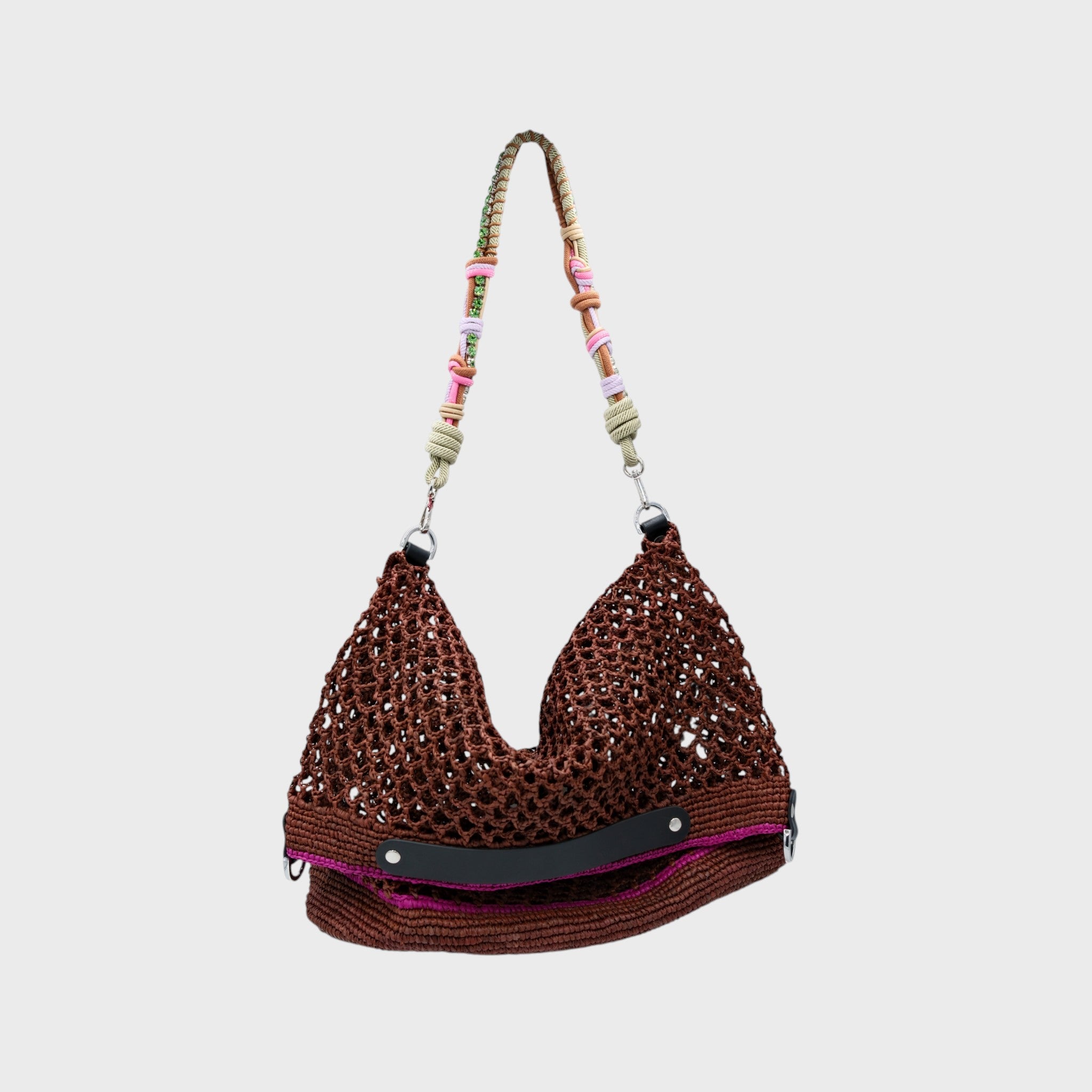 A Brown raffia Colin Tote Bag with pink stripes, hanging by a green, pink and small green stones beaded bag strap. 