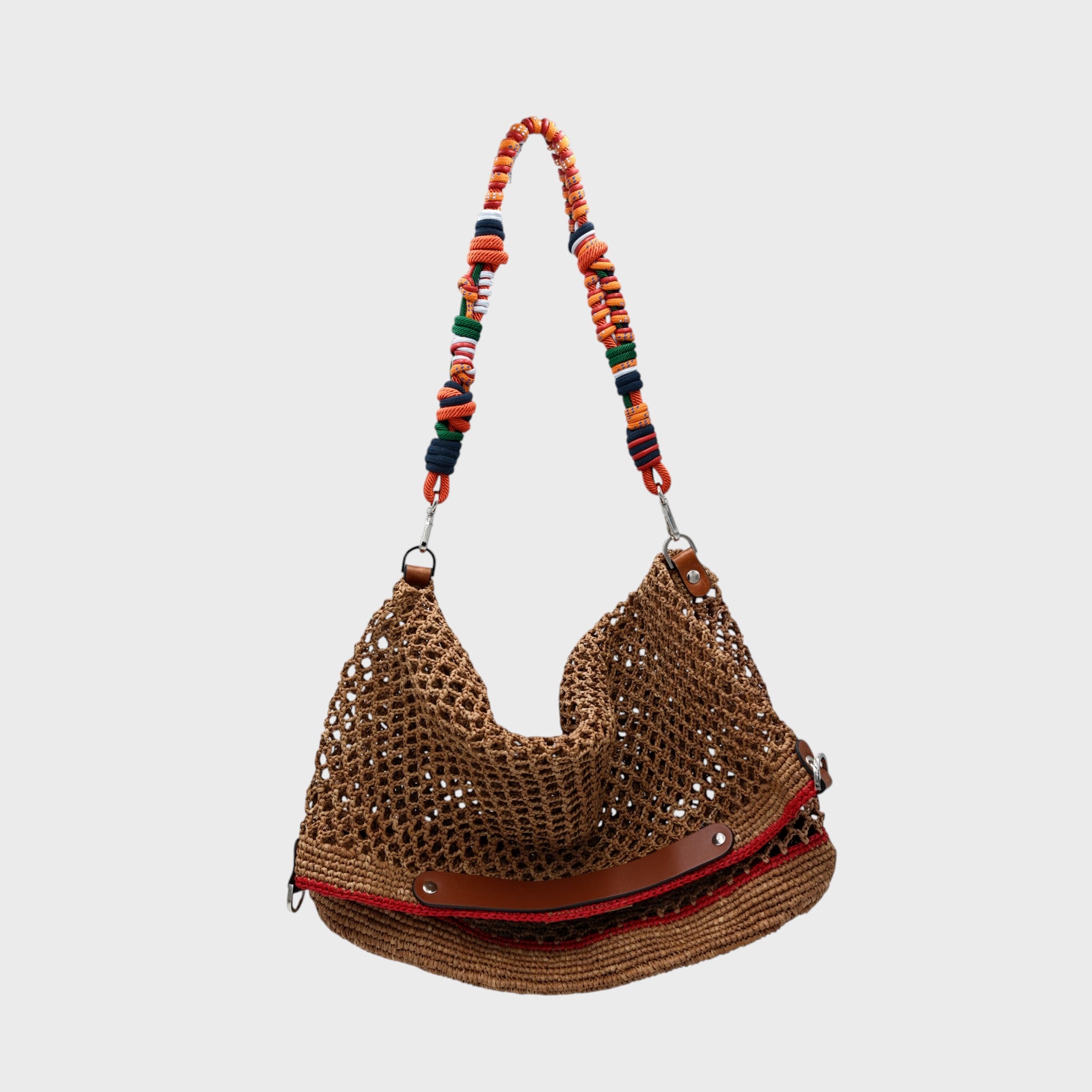 A Brown raffia Colin Tote Bag with red stripes, hanging by a orange, grene and red beaded bag strap. 