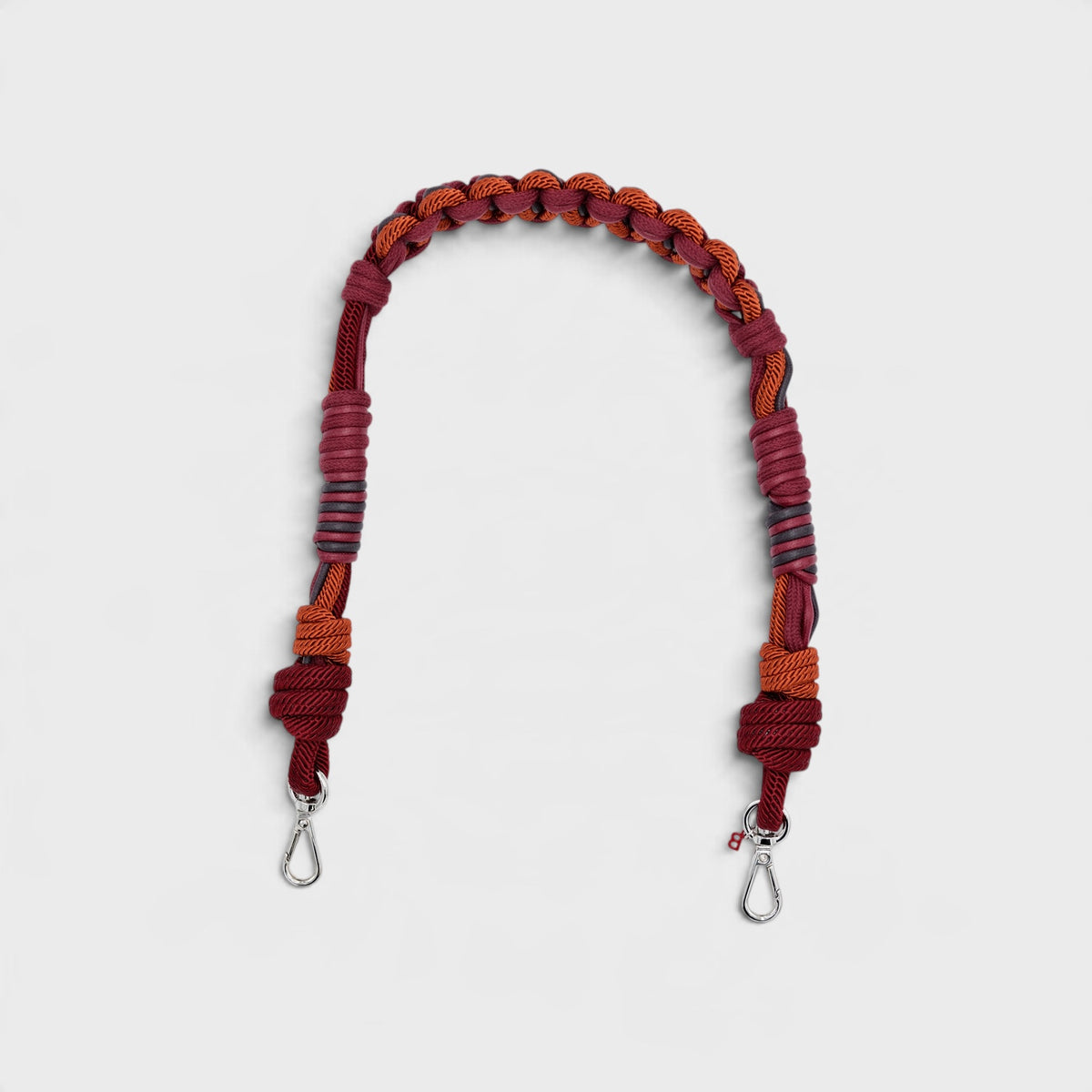 Burgundy macramé woven bag strap with metal clasps on a white background