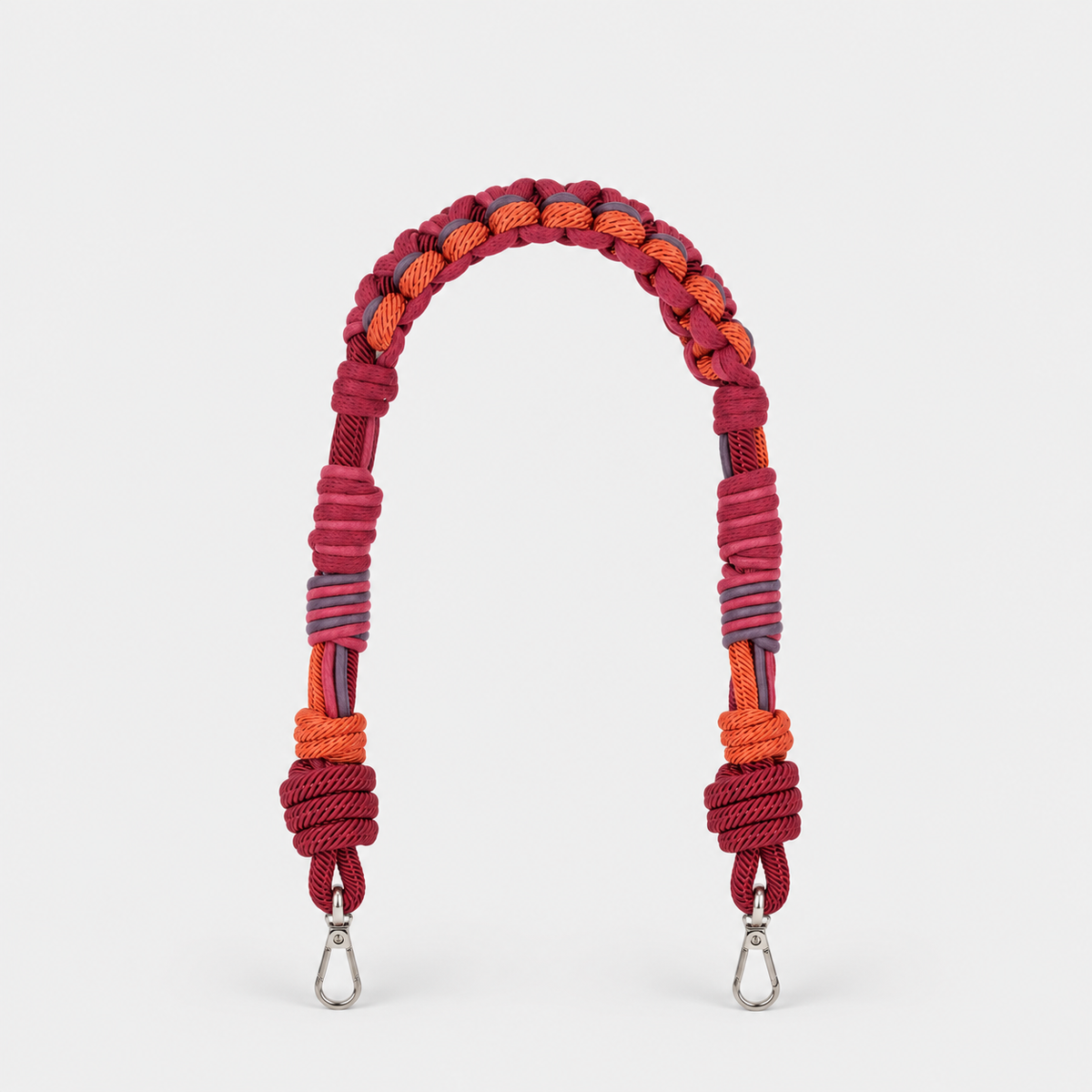 Burgundy macramé woven bag strap with metal clasps on a white background