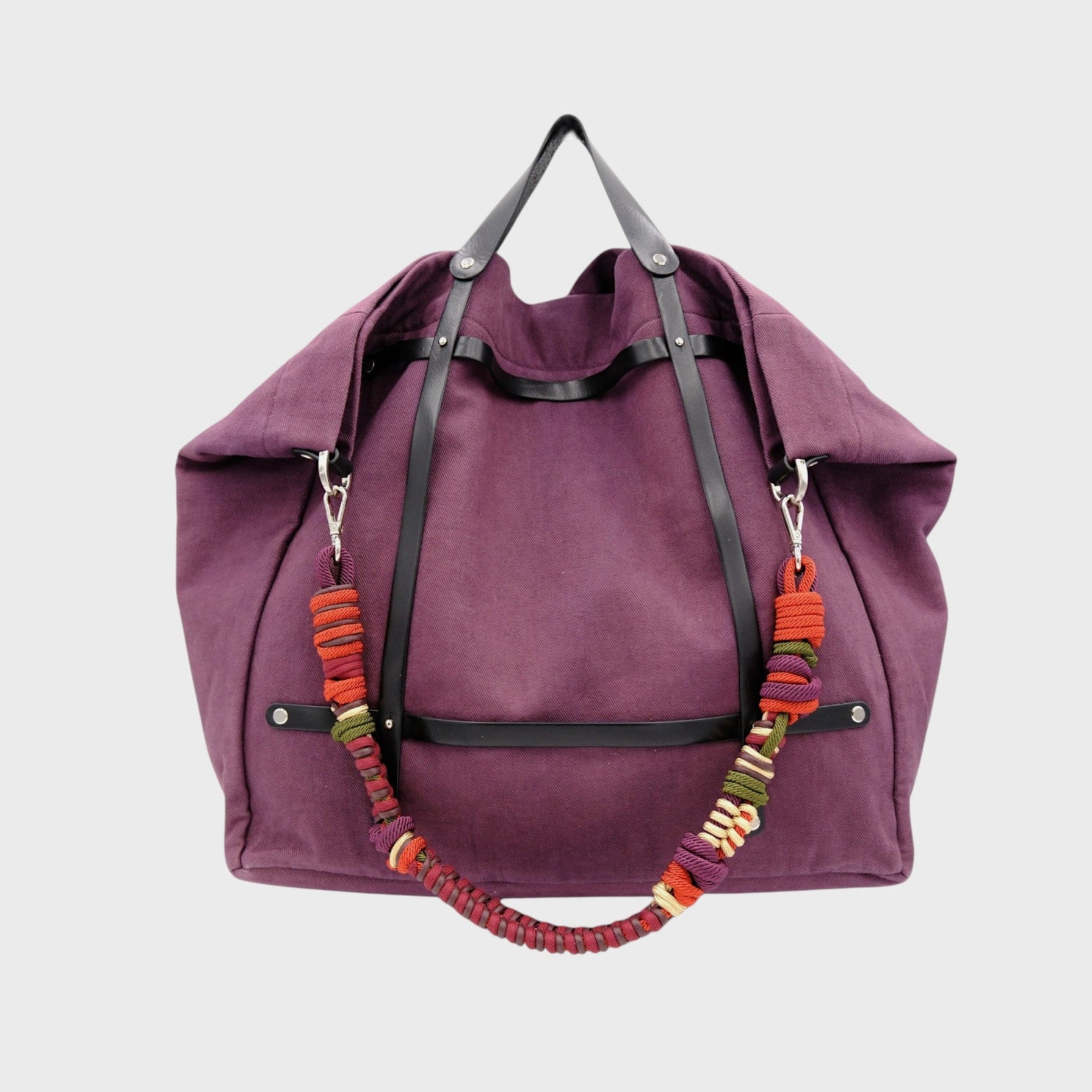 Aubergine weekend or duffle bag in canvas with a black leather harness, paired with a colourful shoulder strap in orange, green and purple.