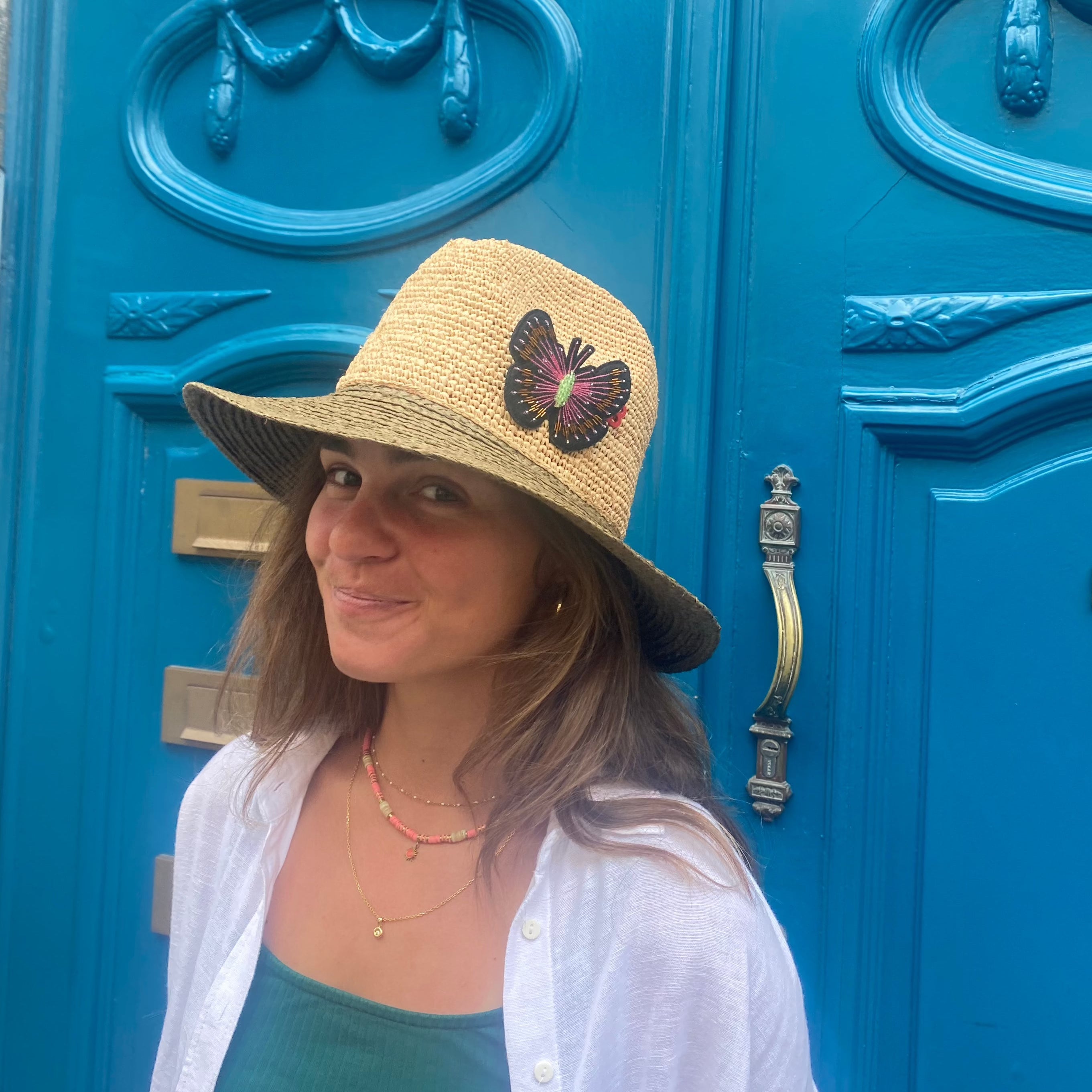 A model wearing on a hate the pink butterfly brooch. 