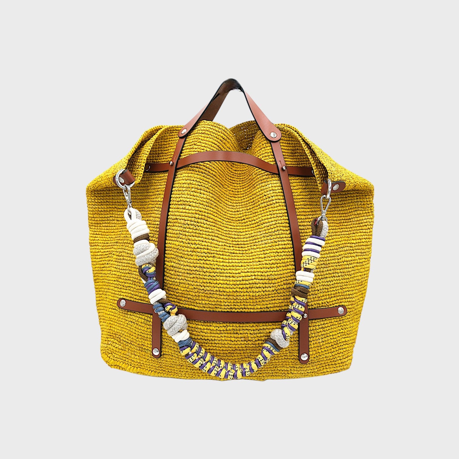 Multicolored braided macramé bag strap in bright yellow, dark green and purple, with white, shown on a yellow raffia CANDIDE Weekender Bag.