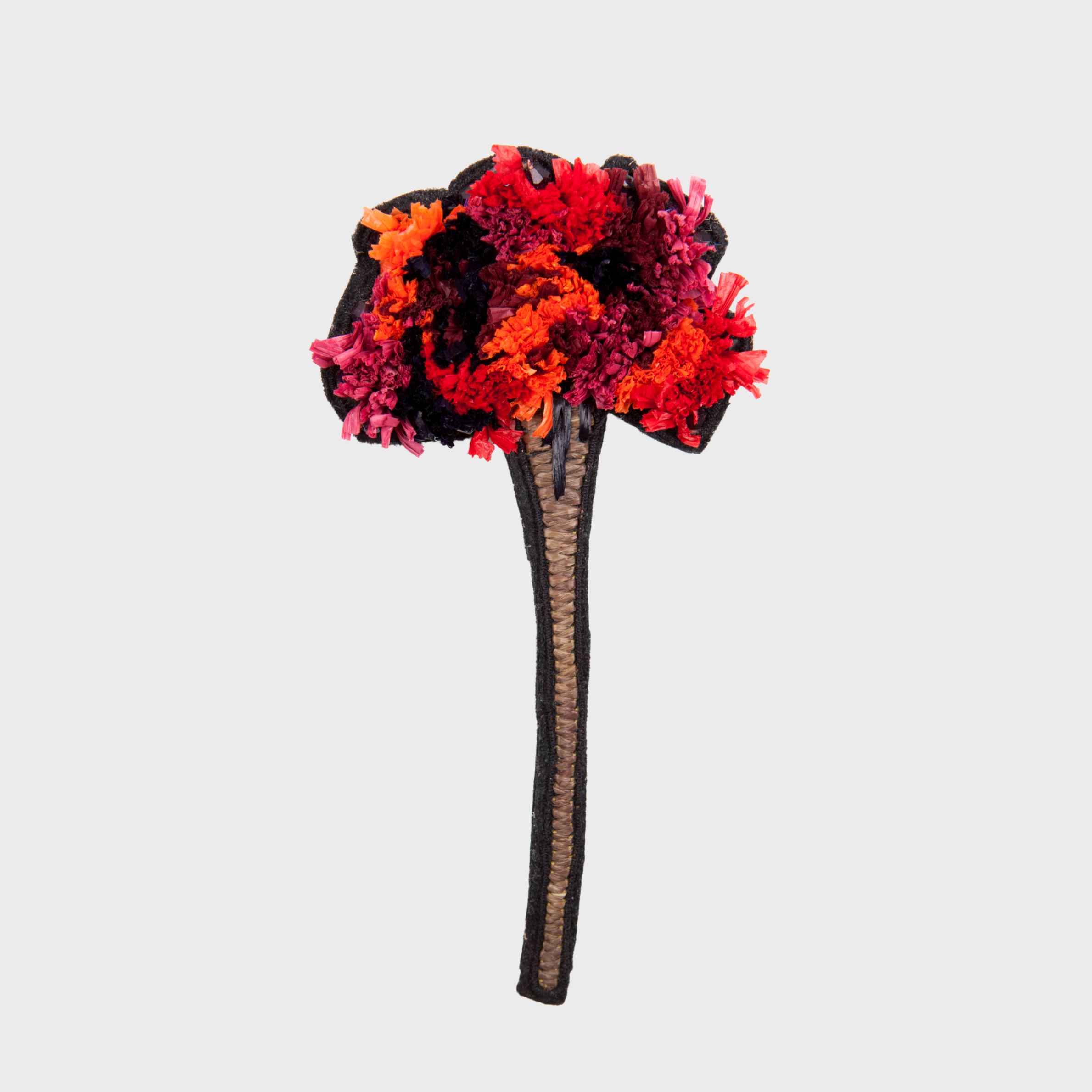 An embroidered brooch representing a long flower with red, orange, and brown details 