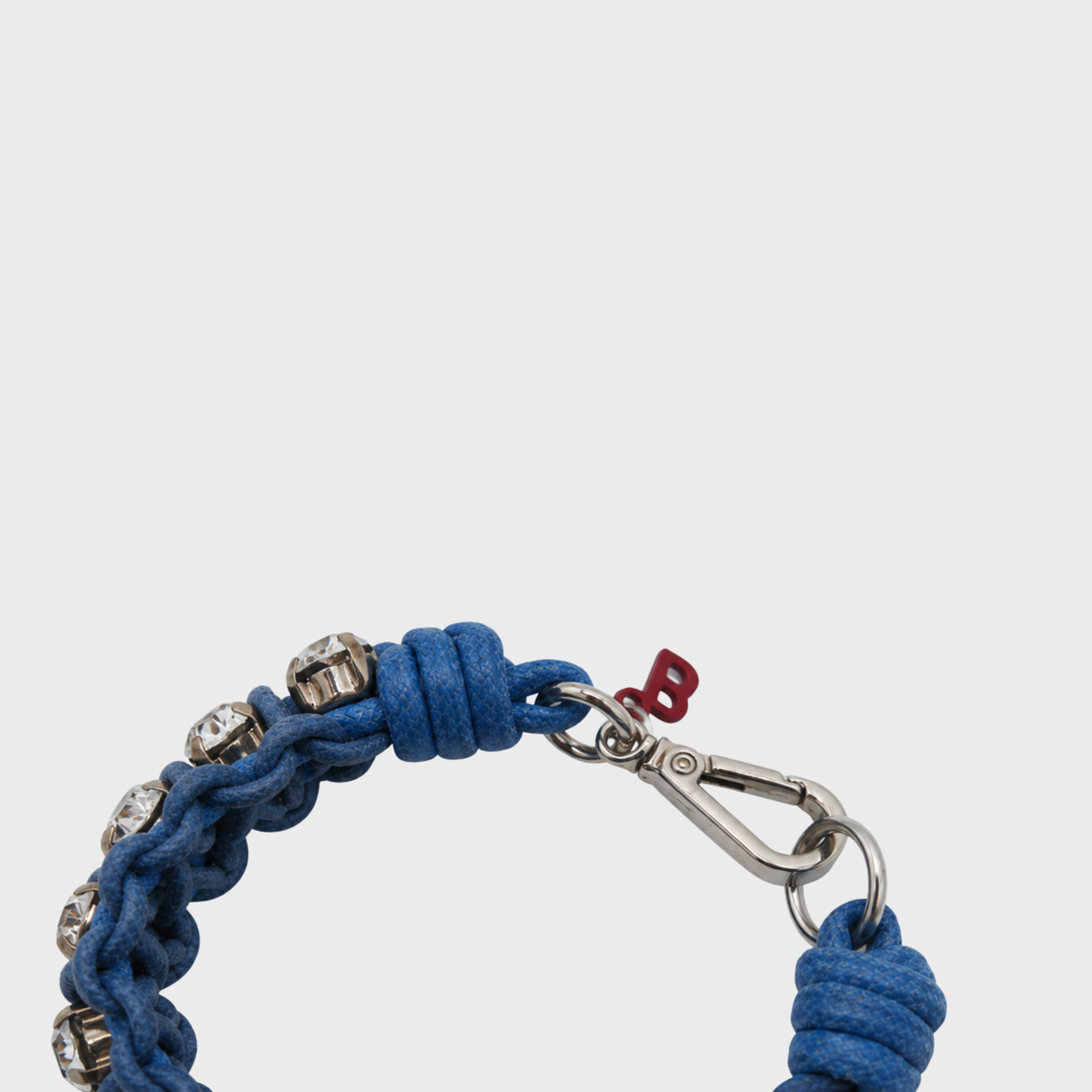 A handmade macramé woven bracelet featuring a mix of blue threads, accented with small white beads and a silver clasp.