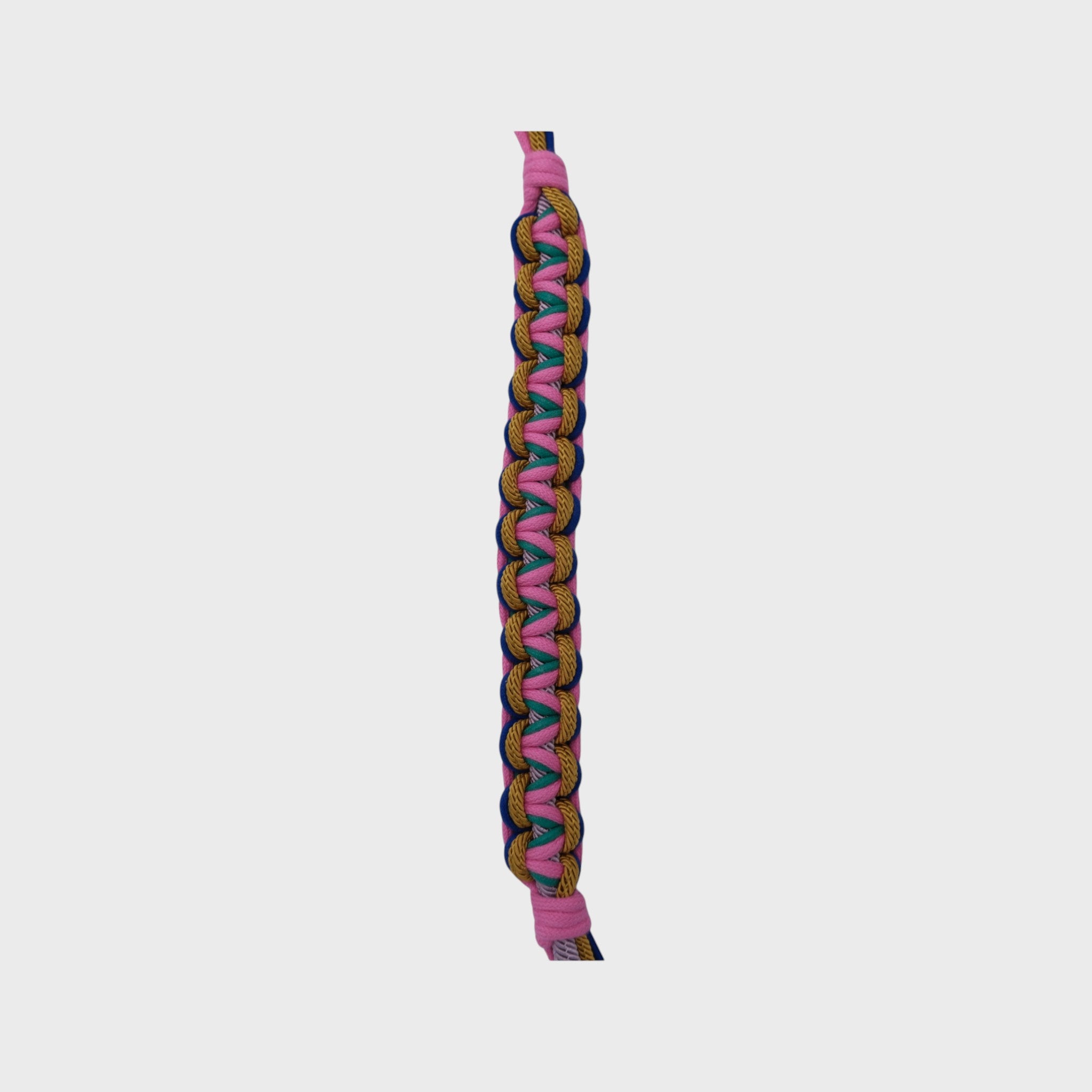 A detailed piece of the multicolored braided macramé bag strap in bright pink, blue, and yellow with metal hooks on a light gray background.
