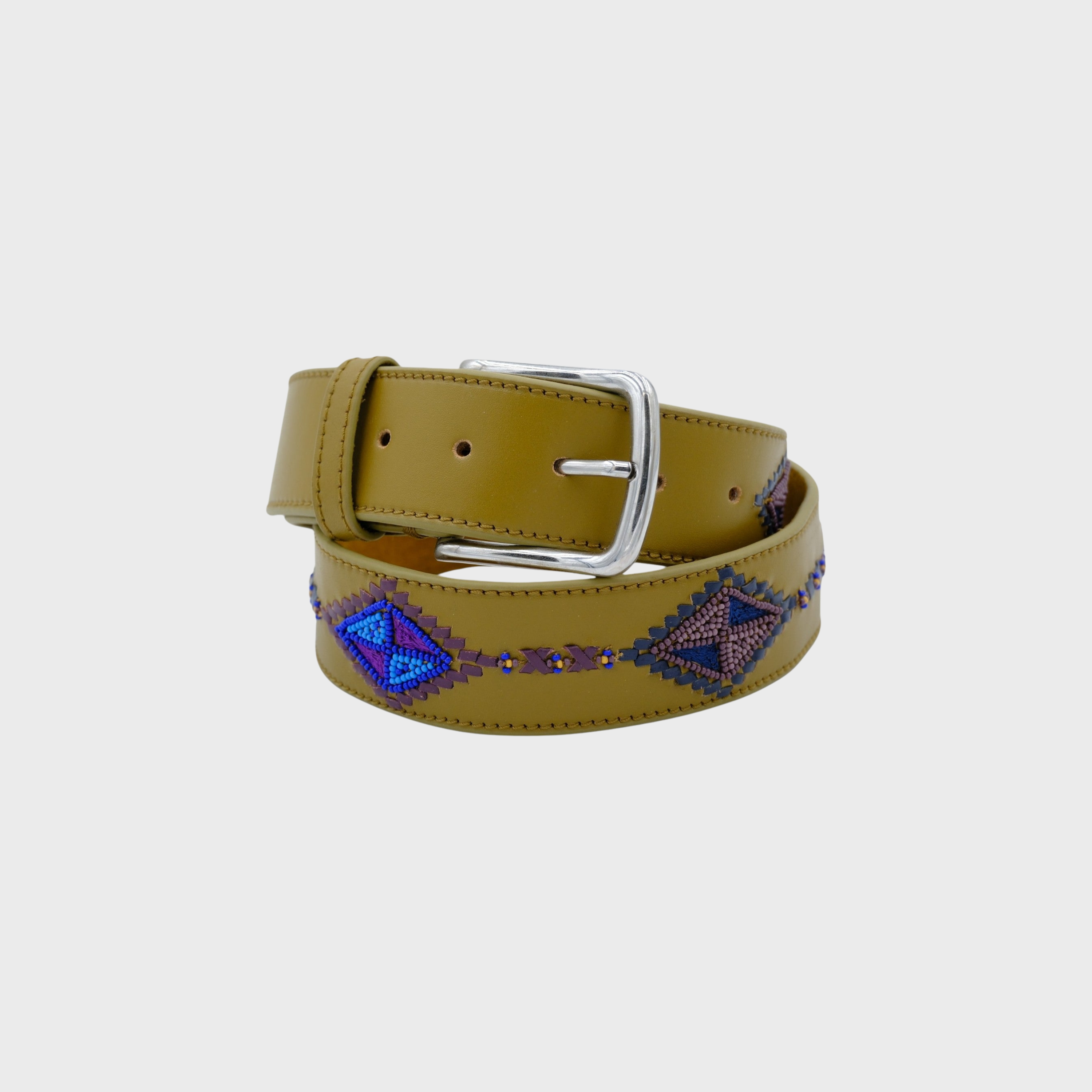 A soft green leather belt with a silver buckle, featuring a diamond shaped pattern in blue, purple, and brown on the strap, coiled on a light gray background.