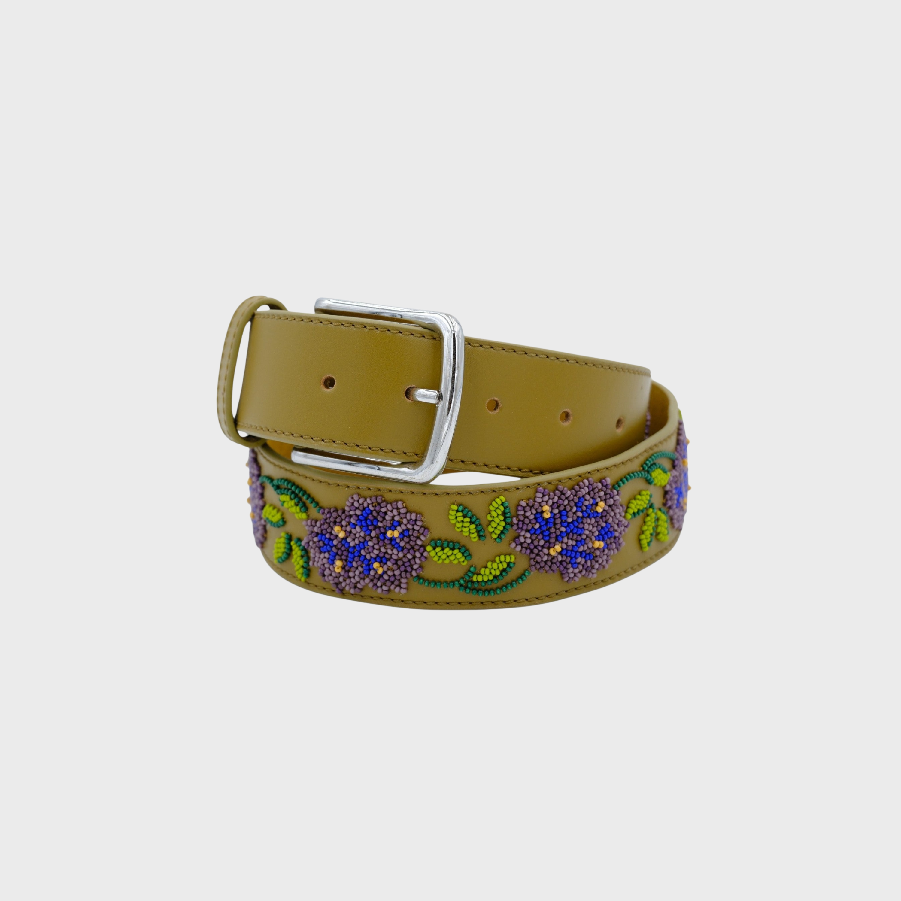 A green leather belt with a silver buckle, decorated with purple and blue floral beadwork and green leaf patterns.
