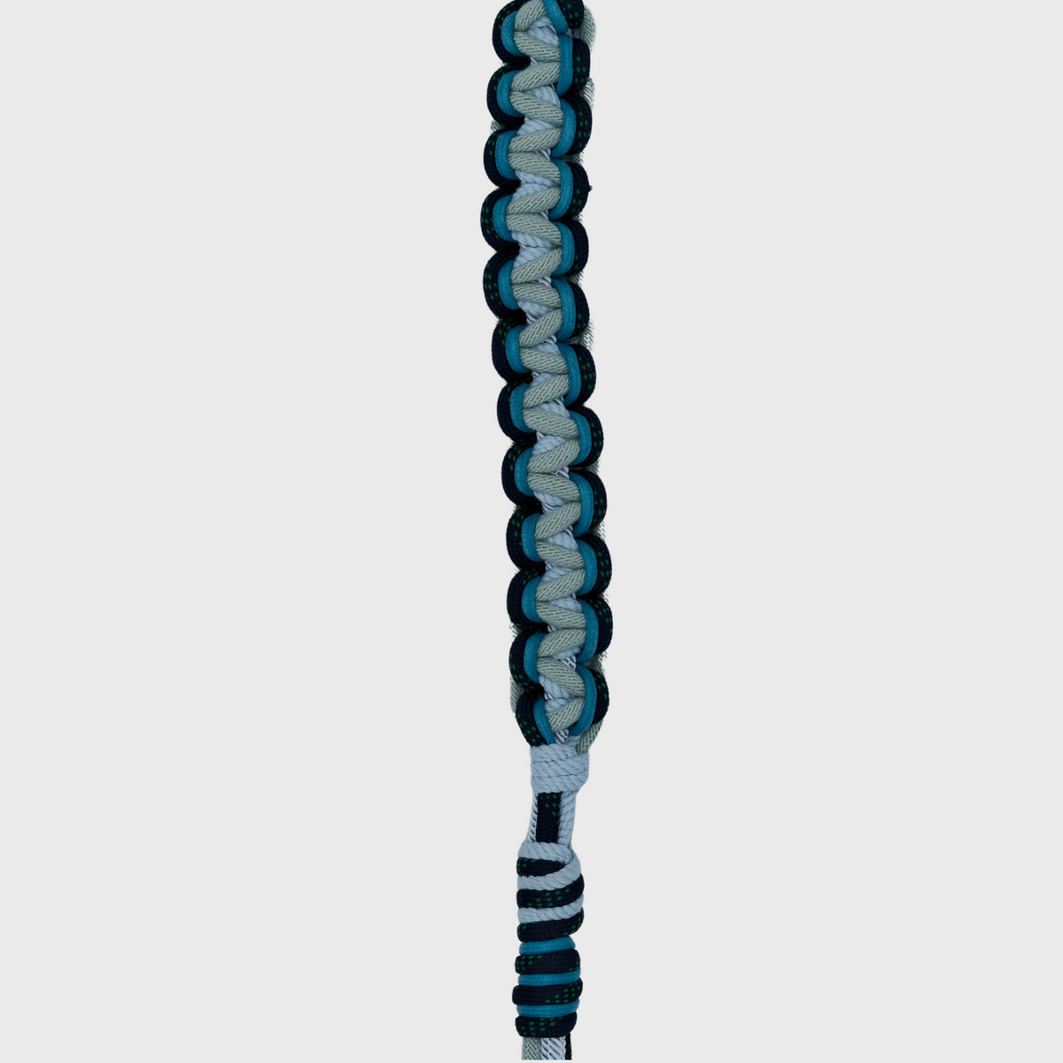 A detail shown of the braided macramé bag strap with a light blue and dark teal pattern, featuring silver metal snap hooks at the ends.