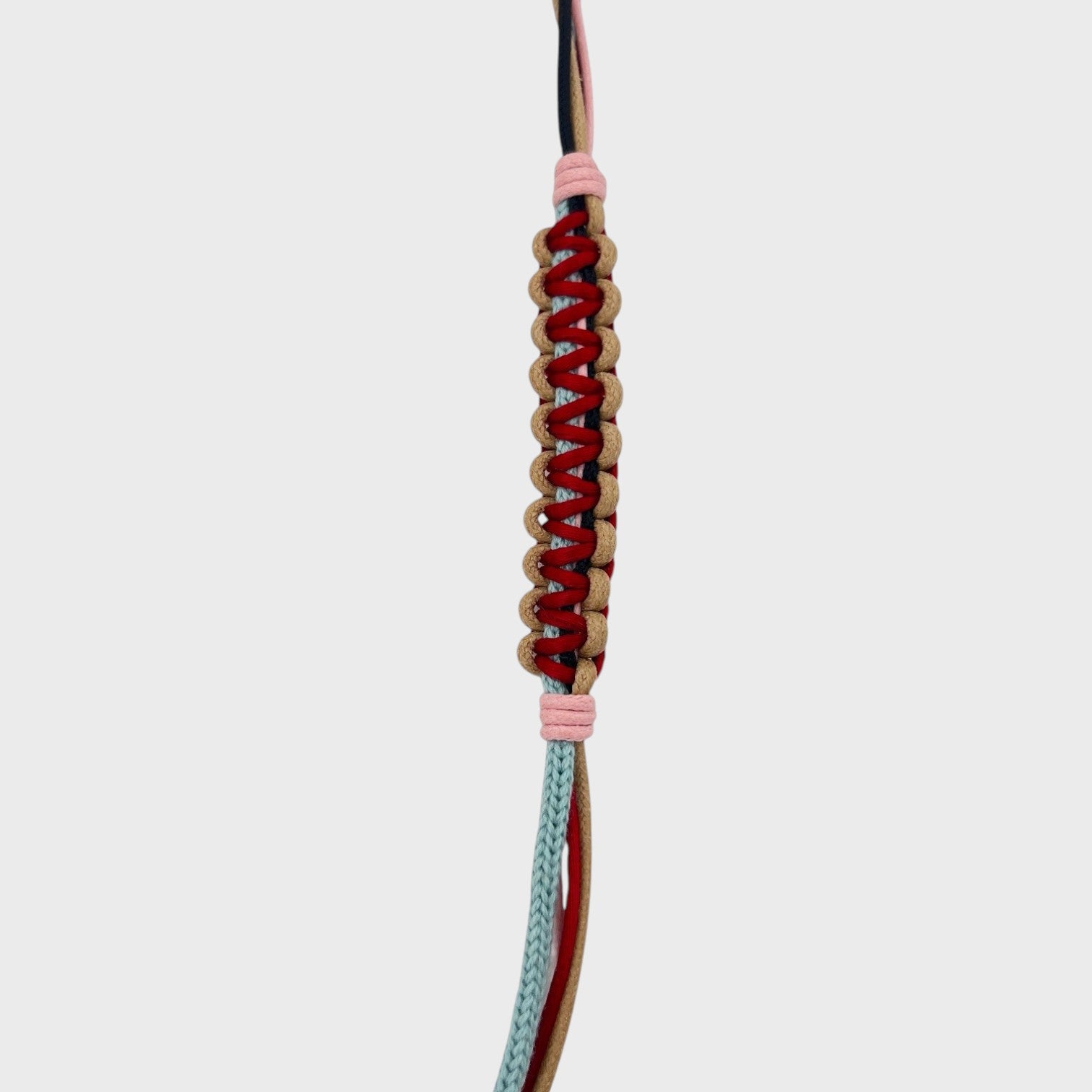 Detail of the beige, red, pink, light blue and dark blue phone lanyard. 