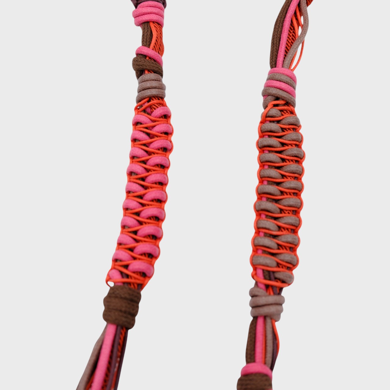 Detail of the red, pink and brown thick phone lanyard. 