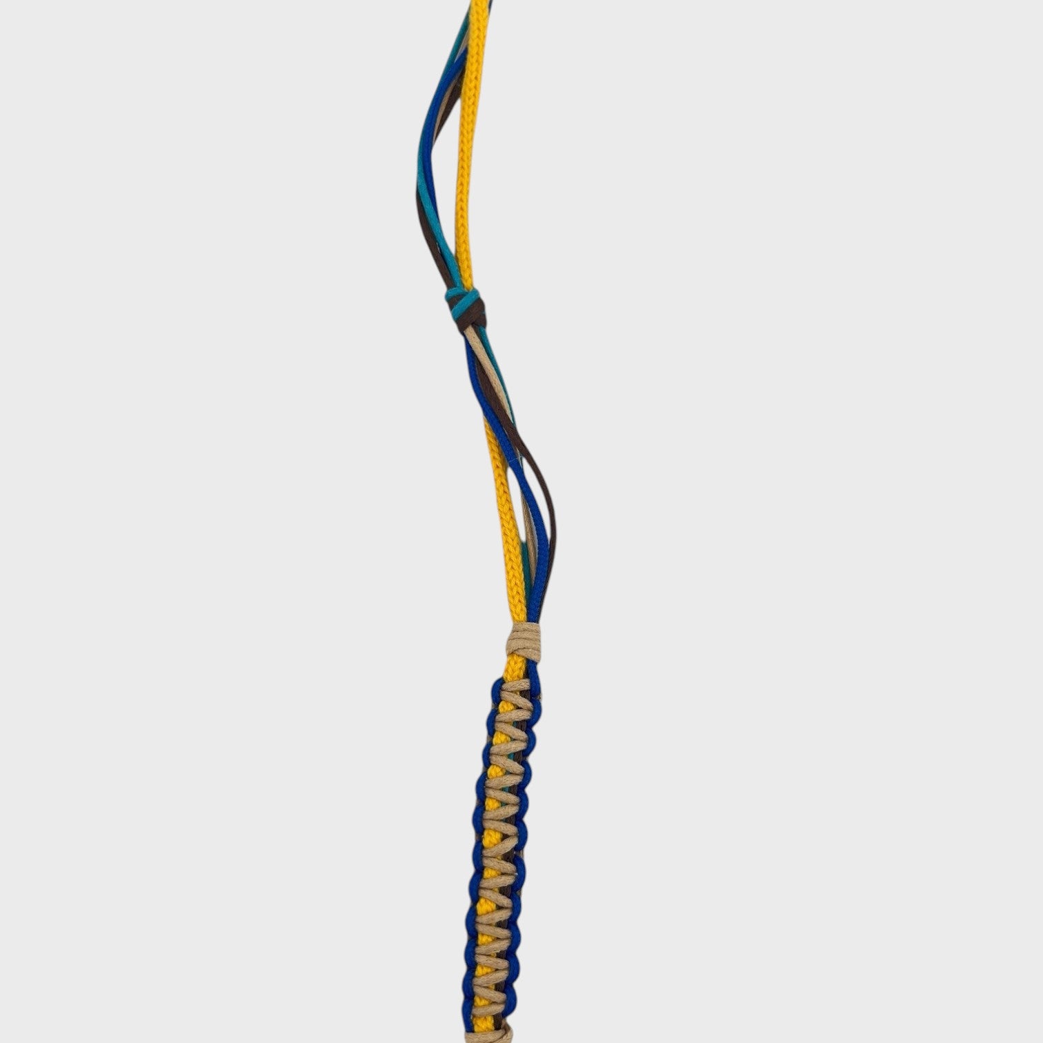 Detail of the yellow, beige, brown, blue and green phone lanyard. 